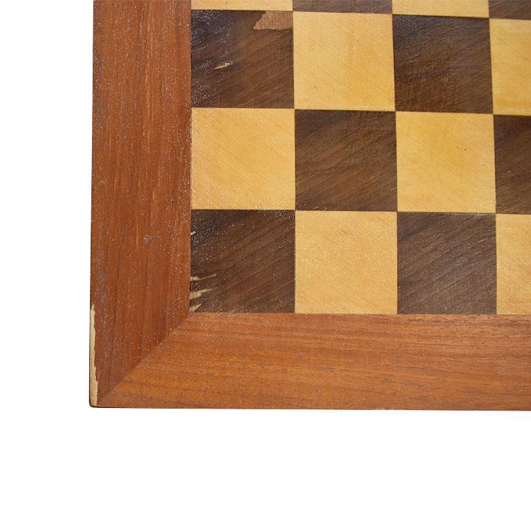 A low square chess or checkers game table. A beautiful piece created from wood. The top features a light and dark brown alternating square veneer wood detail. Some wear to the top including the veneer missing. (See photos) 

The legs are the