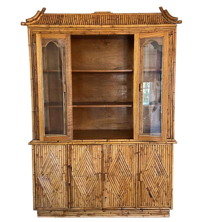 A large Hollywood Regency or Chinoiserie tortoise or burnt bamboo china cabinet. This piece breaks down with the top separating from the bottom credenza. The top features glass doors and sides, with three long solid wood shelves inside. The four