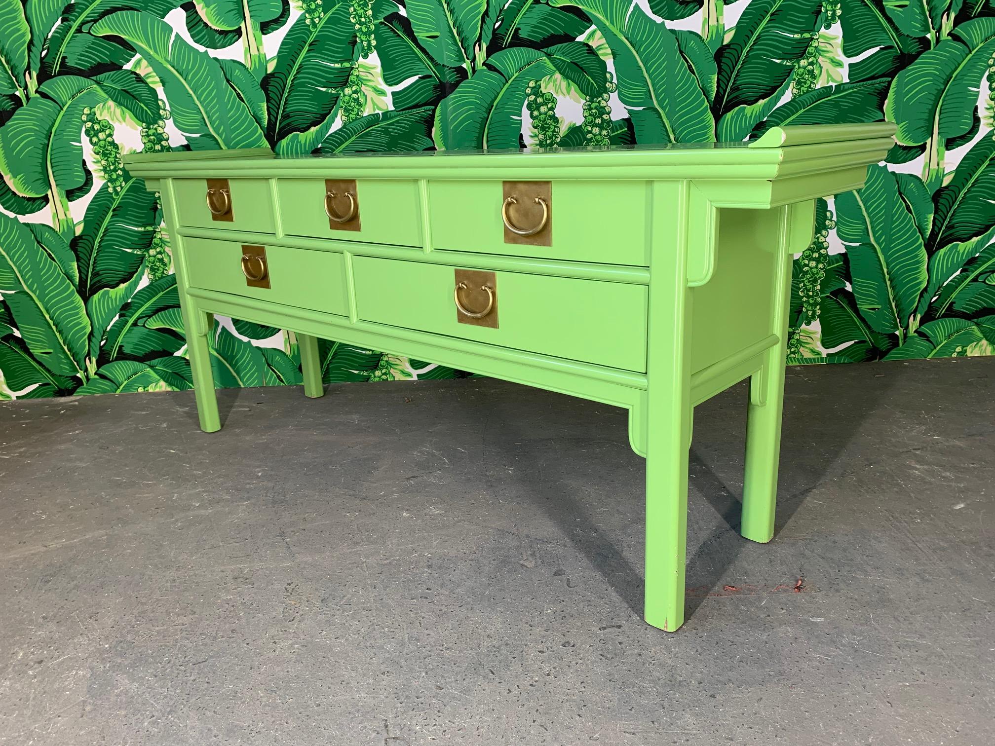 Asian chinoiserie style console table by Century Furniture features heavy brass hardware and a glossy green lacquered finish. Very good condition with minor imperfections to the finish.