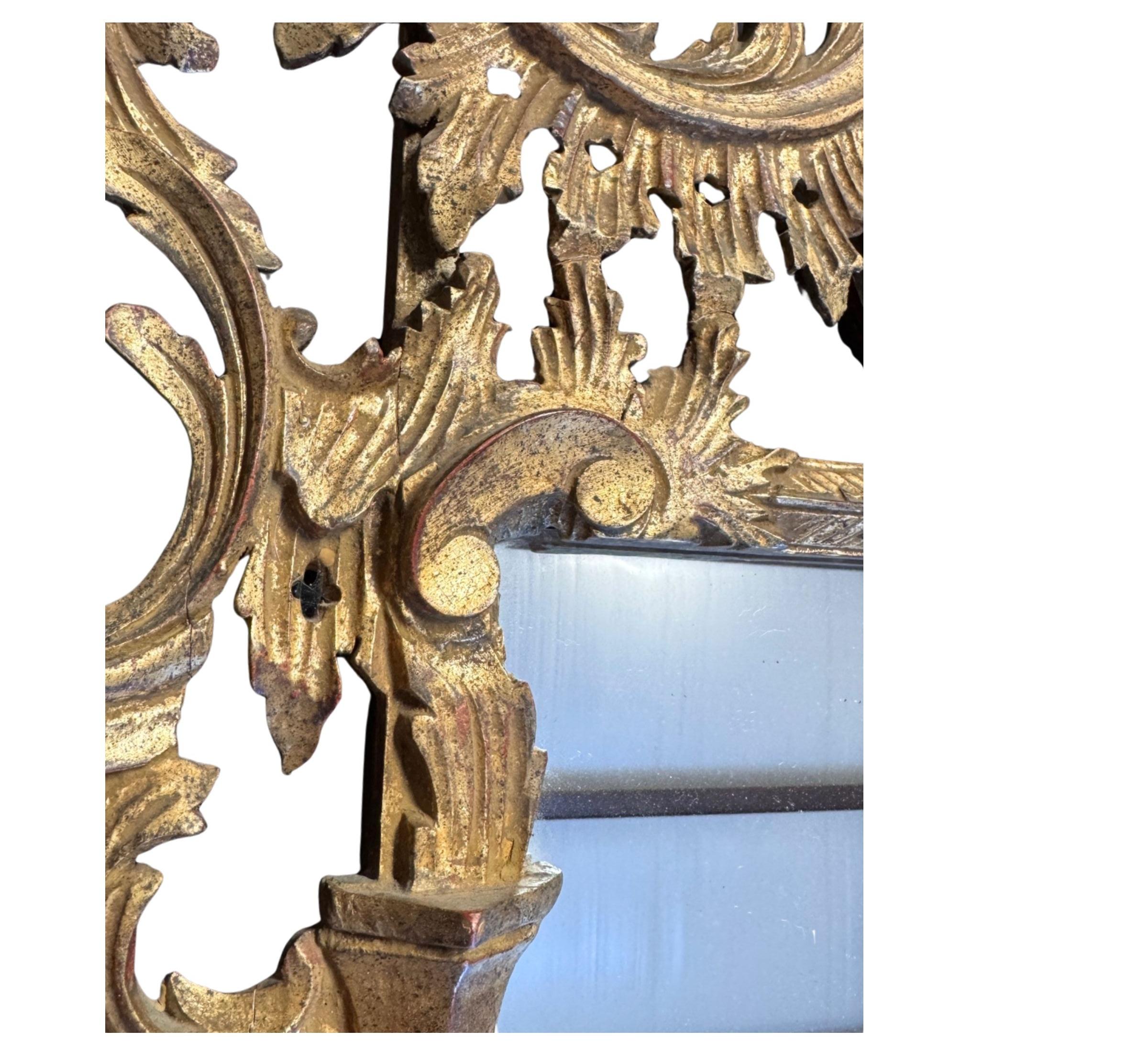 Miroir vintage en bois doré fabriqué en Italie, dans le style Chippendale chinois, avec une crête de pagode à cinq cloches et une décoration florale ornementale sculptée sur l'ensemble du miroir. Ce miroir est un merveilleux exemple de chinoiserie