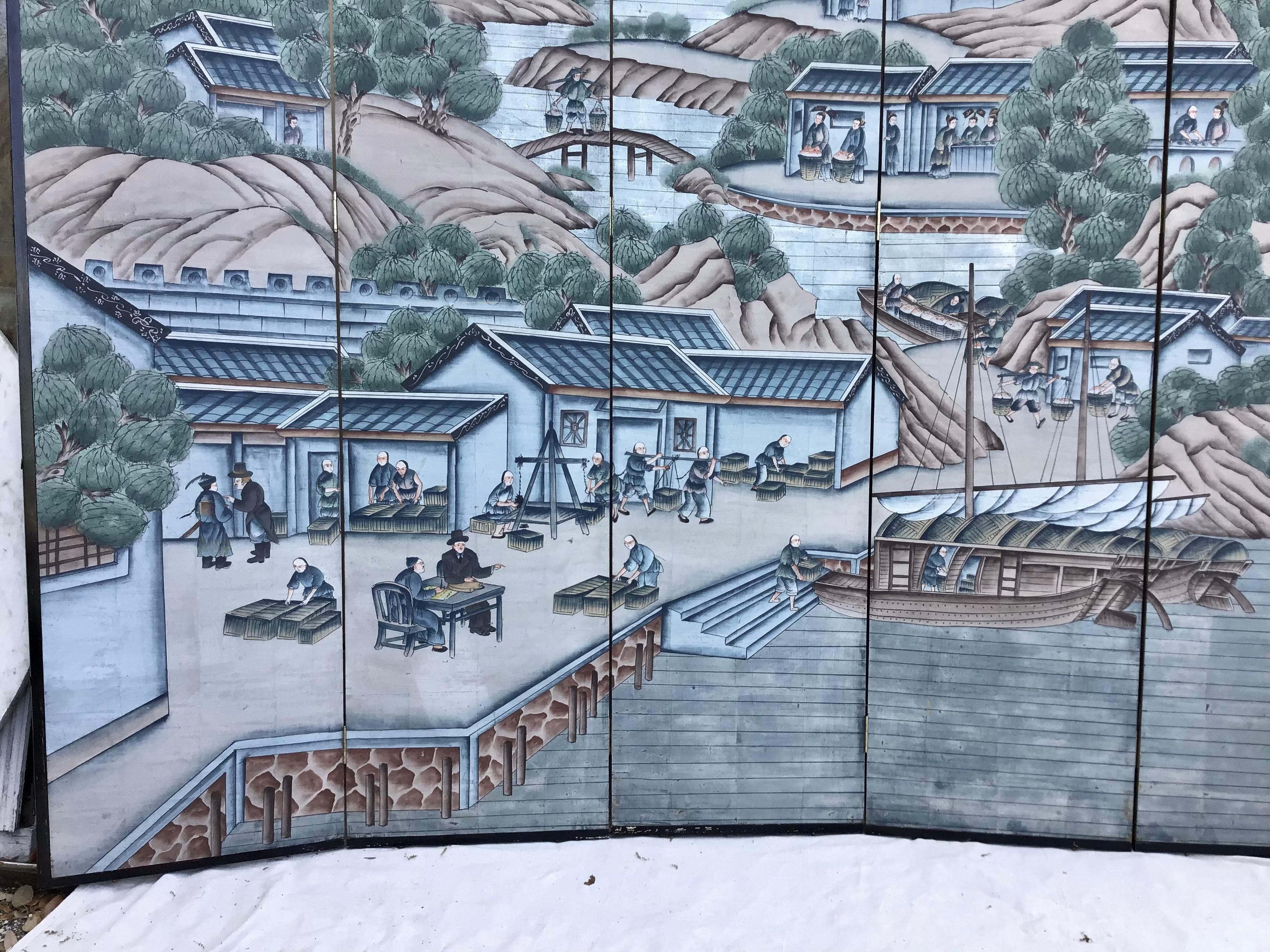 An elegant Chinoiserie six panel wallpaper Screen attributed to Gracie. The image depicted is that of a Chinese Village on the water bustling with activity. Showing figures at various jobs along the waterfront. A river running down from the