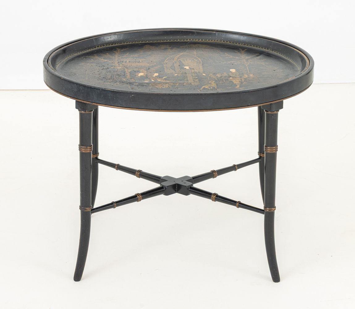 Chinoiserie Papier Mache Oval Tray Table, the oval top with painted and gilt figural courtyard scene above later faux bamboo legs conjoined by X-form stretcher. 19