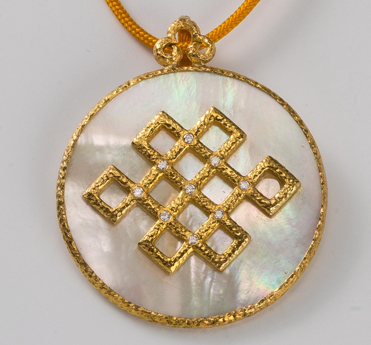 From our Heritage Collection of Chinoiserie designs, the luminous mother-of-pearl pendant is wrapped in hammered gold with an endless knot motif decorated with diamonds, 1 3/8 in (3.5cm) dia. The endless knot motif is a Buddhist symbol of eternity,