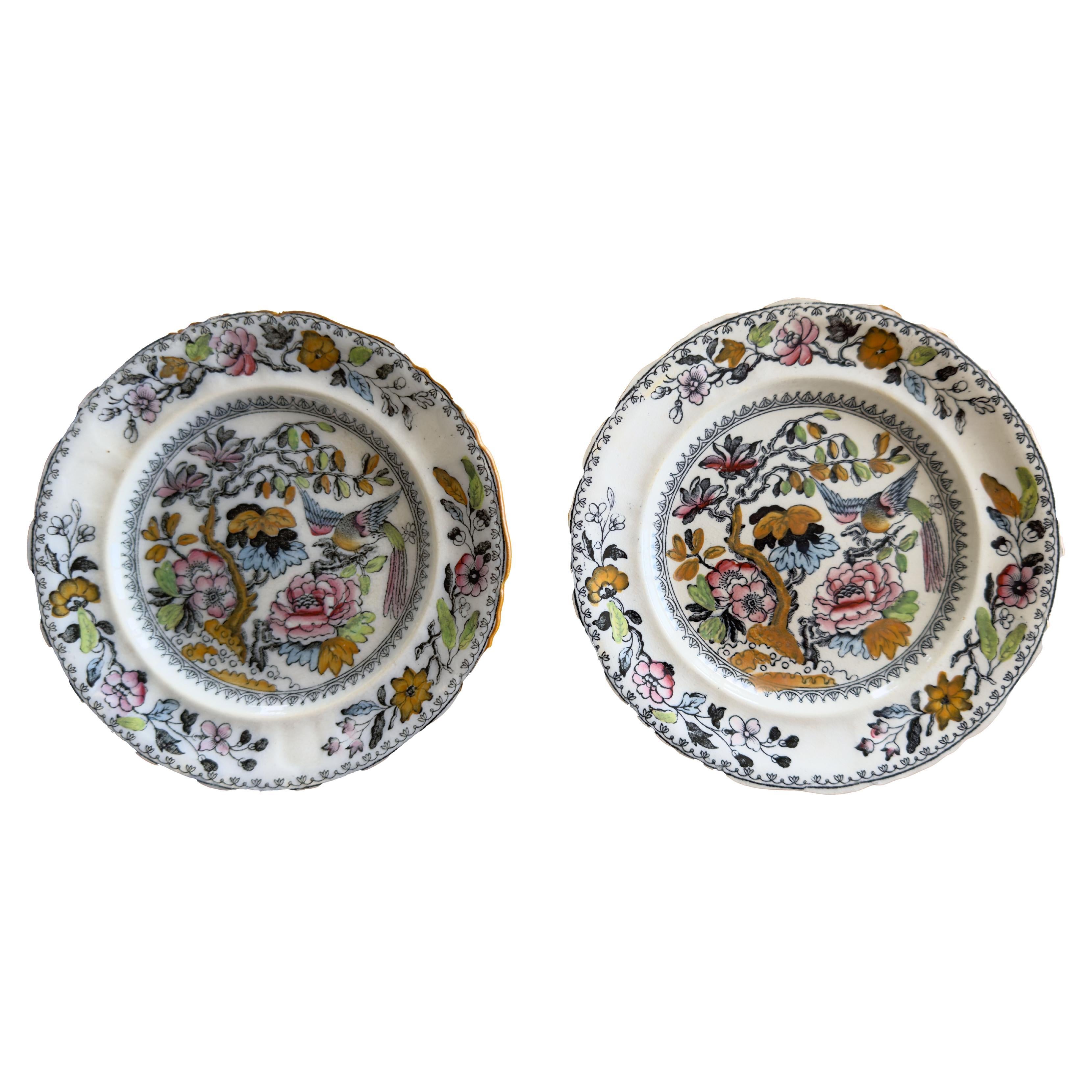 A beautiful pair of antique small antique plates with oriental flowers and birds by Ashworth. With scalloped rims. The Ashworth crown and banner mark is on the back. Circa 1890s, England.