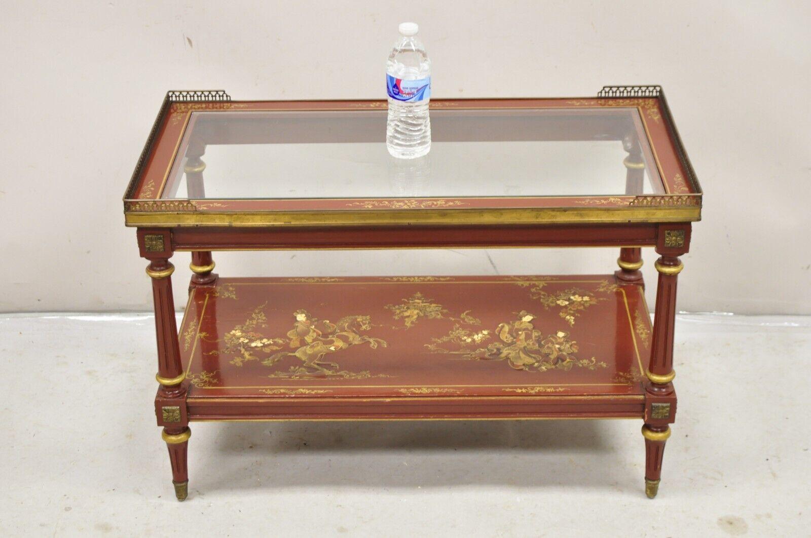 Vintage Chinoiserie Red Lacquer Gold Gilt Oriental / Asian Inspired Hand Painted Glass Top Coffee Table. Item features 2 tiers, unique painted details, brass ormolu and gallery, very nice vintage coffee table. Circa Early to Mid 20th Century.