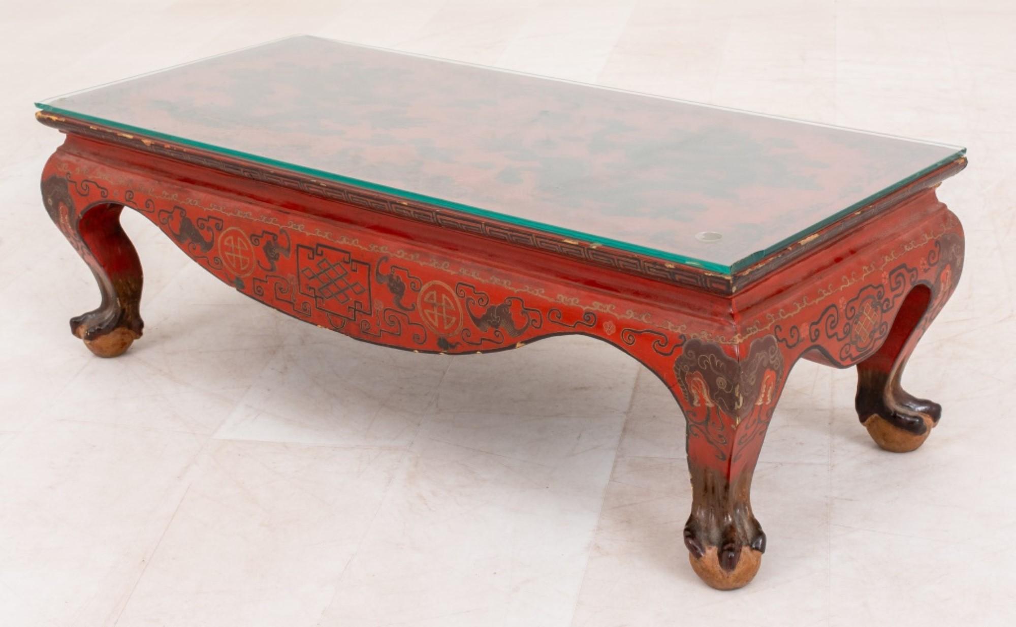 The Chinoiserie manner red lacquered and gilt decorated low table measures approximately 10.5 inches in height, 31.5 inches in length, and 13.5 inches in depth (approximate measurements).




