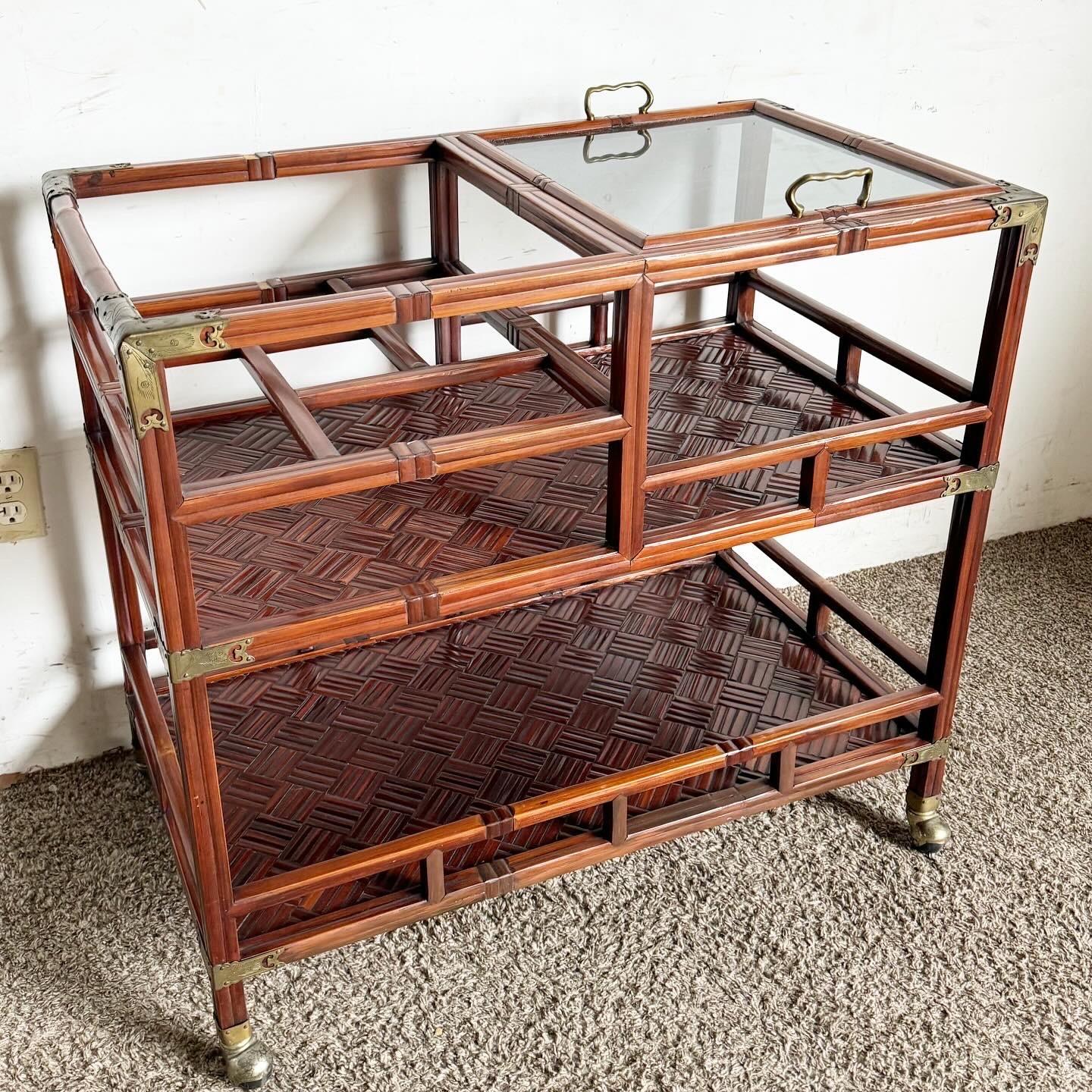 Delve into the elegance of traditional Chinoiserie style with this Rose Finish Rattan and Brass Bar/Tea Cart. Featuring a sophisticated rose finish with brass accents and a top smoked glass tray, this piece combines vintage luxury with functional