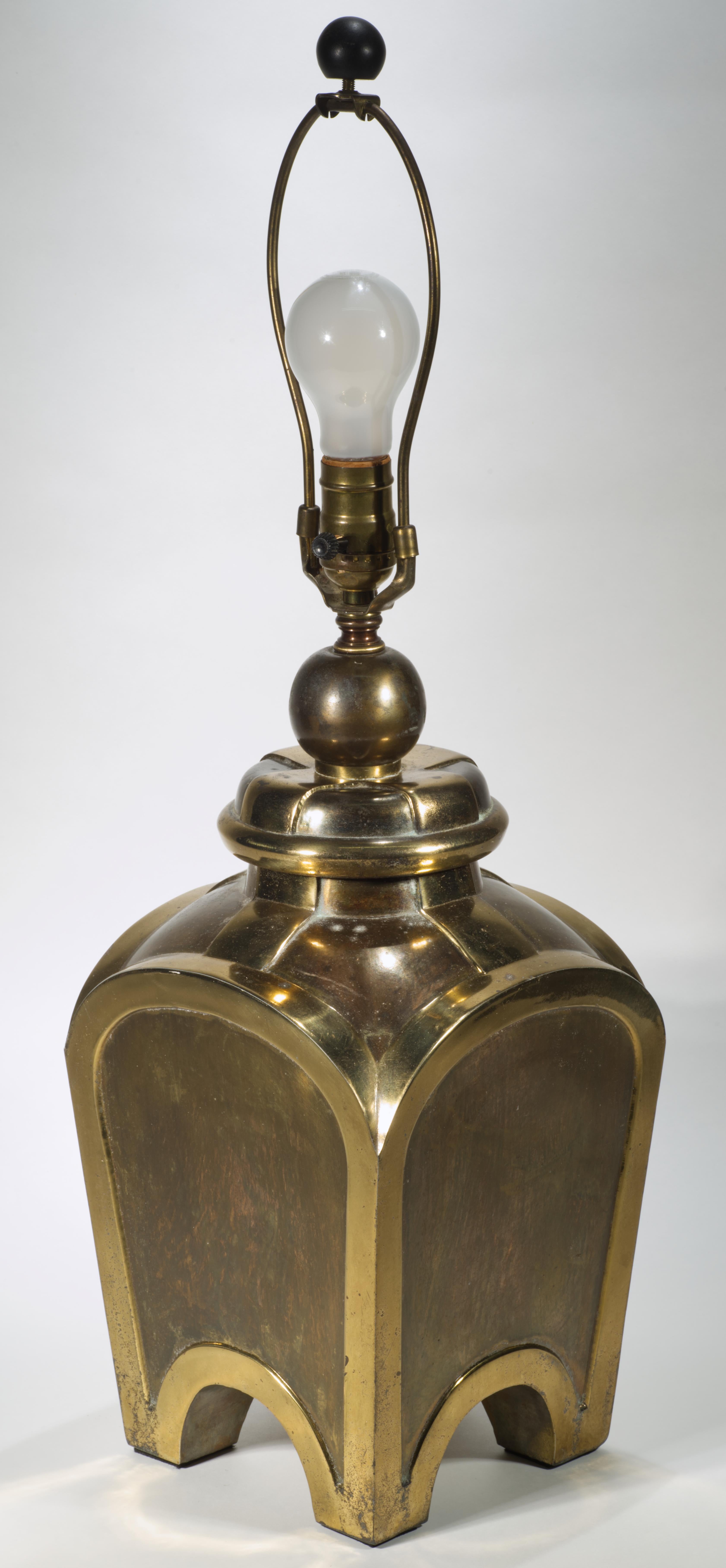 Vintage brass table lamp features a rectangular urn shaped base in Chinoiserie style; the rounded, arched sides show strong Streamline Moderne and Art Deco styles influence that continues to sculptural, graphic urn cover with relief elements and