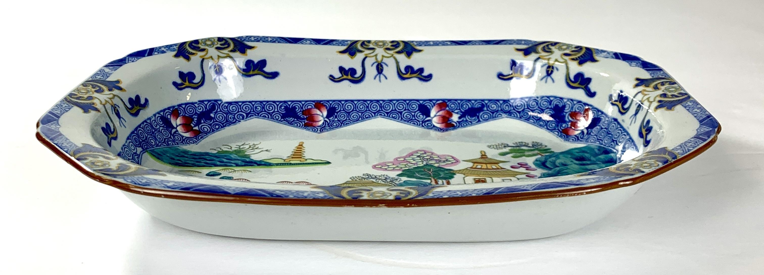 The center of this small English deep dish shows a dream-like chinoiserie scene.
It's a waterside view with trees emanating from rockwork, islands in the water, a pagoda, and houses with oriental-style roofs.
Each item is well painted in an
