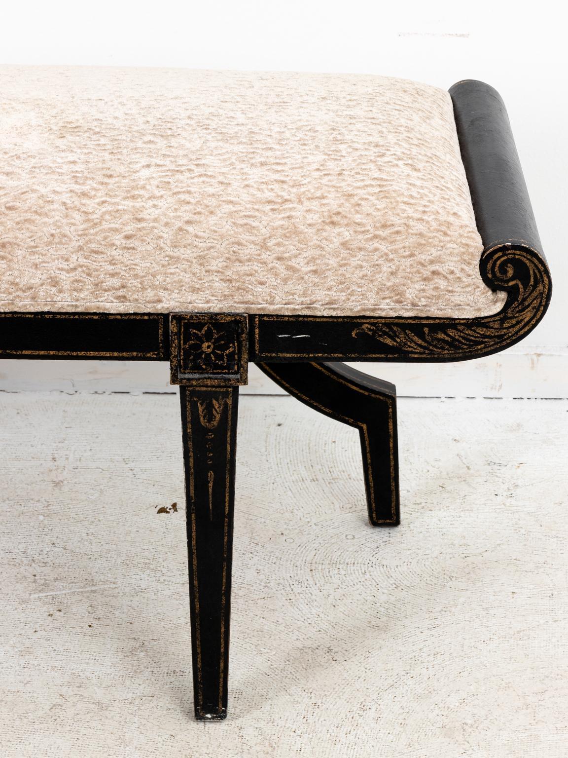 Black and gold chinoiserie style bench with upholstered seat, painted floral, and painted acanthus leaf detail on the wood frame, circa 21st century. Please note of wear consistent with age including minor chips and paint loss.