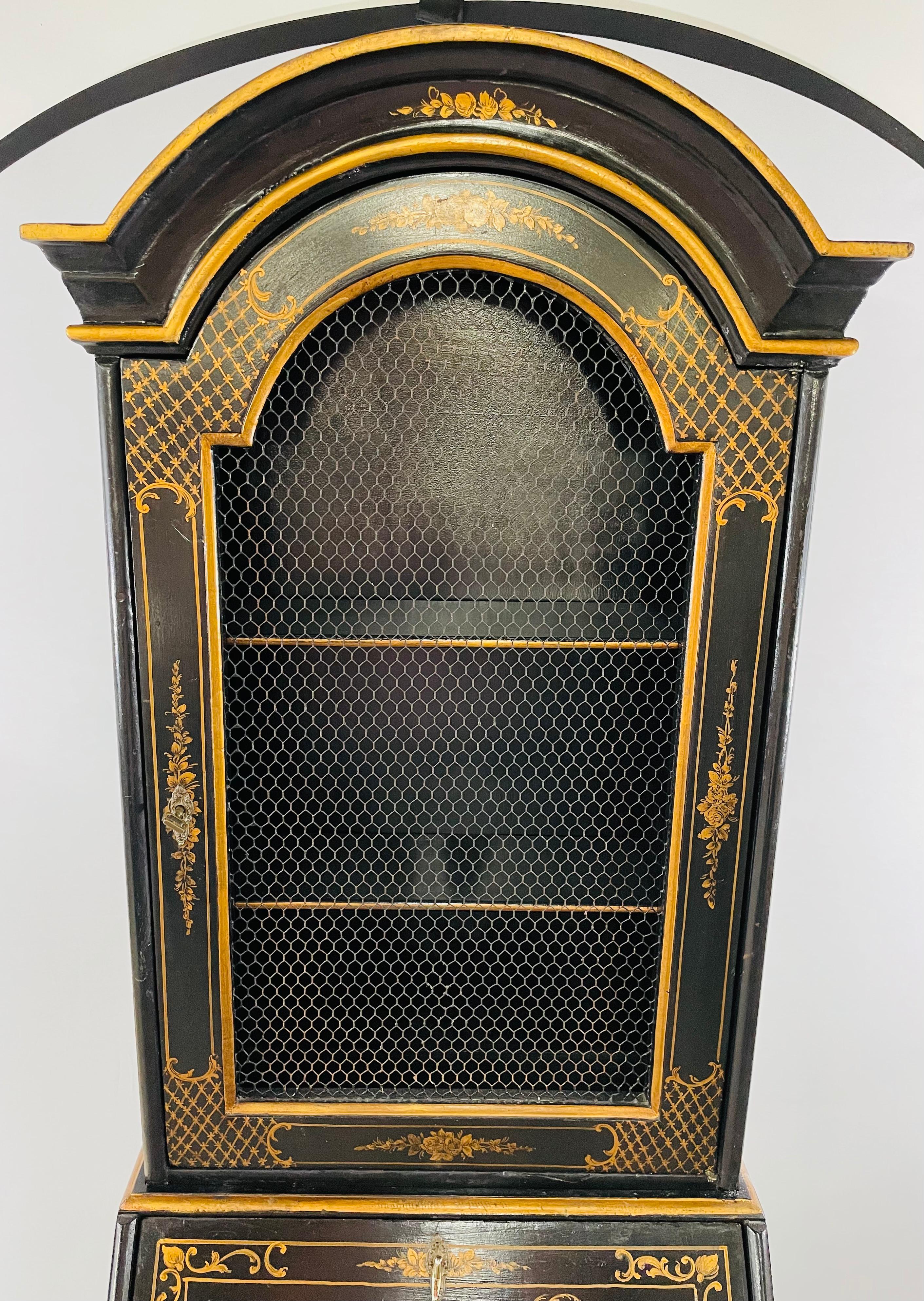 A beautiful Chinoiserie style carved black lacquer secretary desk having a black lacquer and gilt slant top. The secretary desk is made in Italy in the Chinese style and features amazing asian scenes. The two piece secretary has a domed shaped