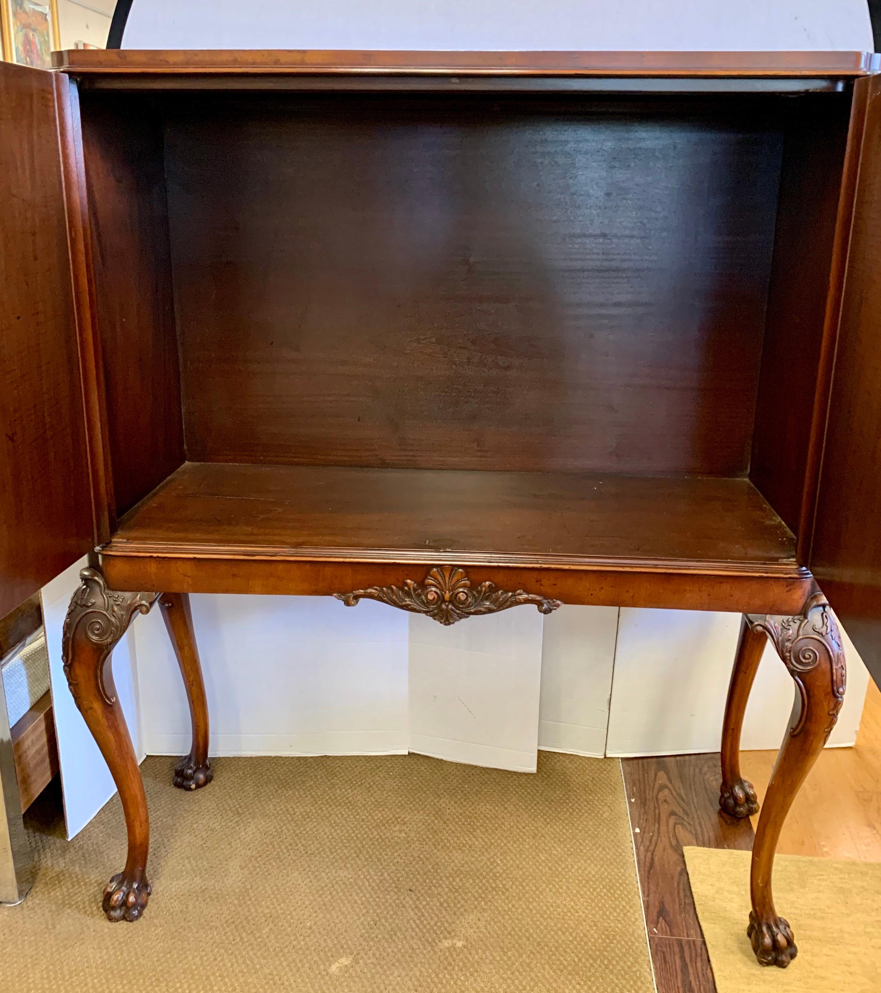 Antique chinoiserie style cabinet raised on four carved legs terminating on hairy paw feet. Versatile cabinet can be used as a dry bar, armoire or television cabinet. Exceptional carved detail and original filigree brass hardware.