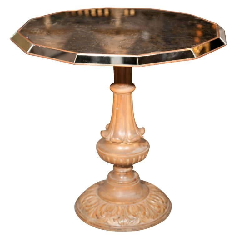 Chinoiserie style center table with eglomise glass top on single pedestal. A fine mirrored with eglomise design tabletop center or end table. The base of wood with scroll carvings on a single pedestal to support the octagonal shaped mirrored frame