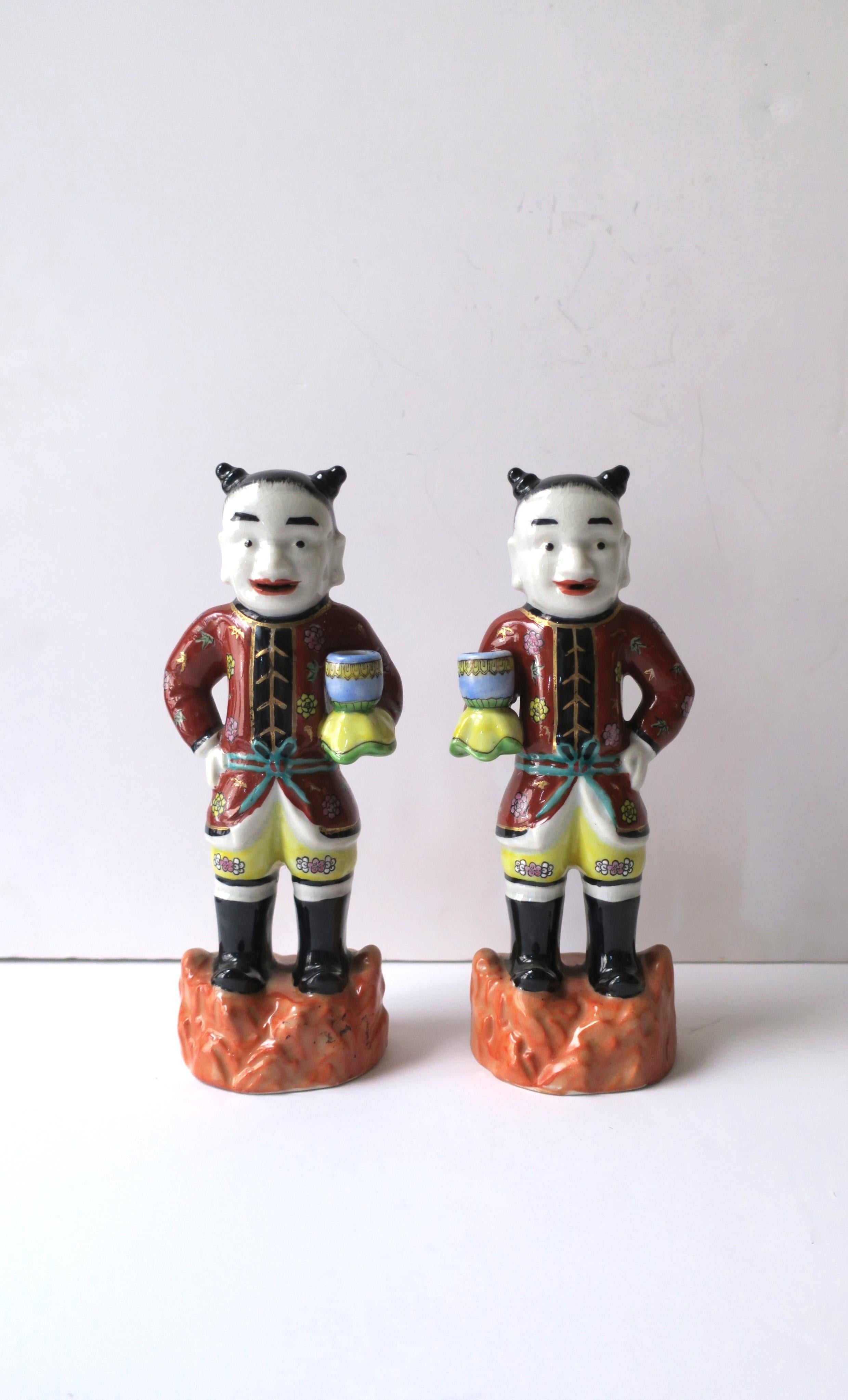 A beautiful pair of hand-painted ceramic Asian male figures, Chinoiserie style, circa mid-20th century, British Hong Kong. Hand painted in both rich and bright colors highlighting their formal attire and ceremonial cup. Pieces are beautifully