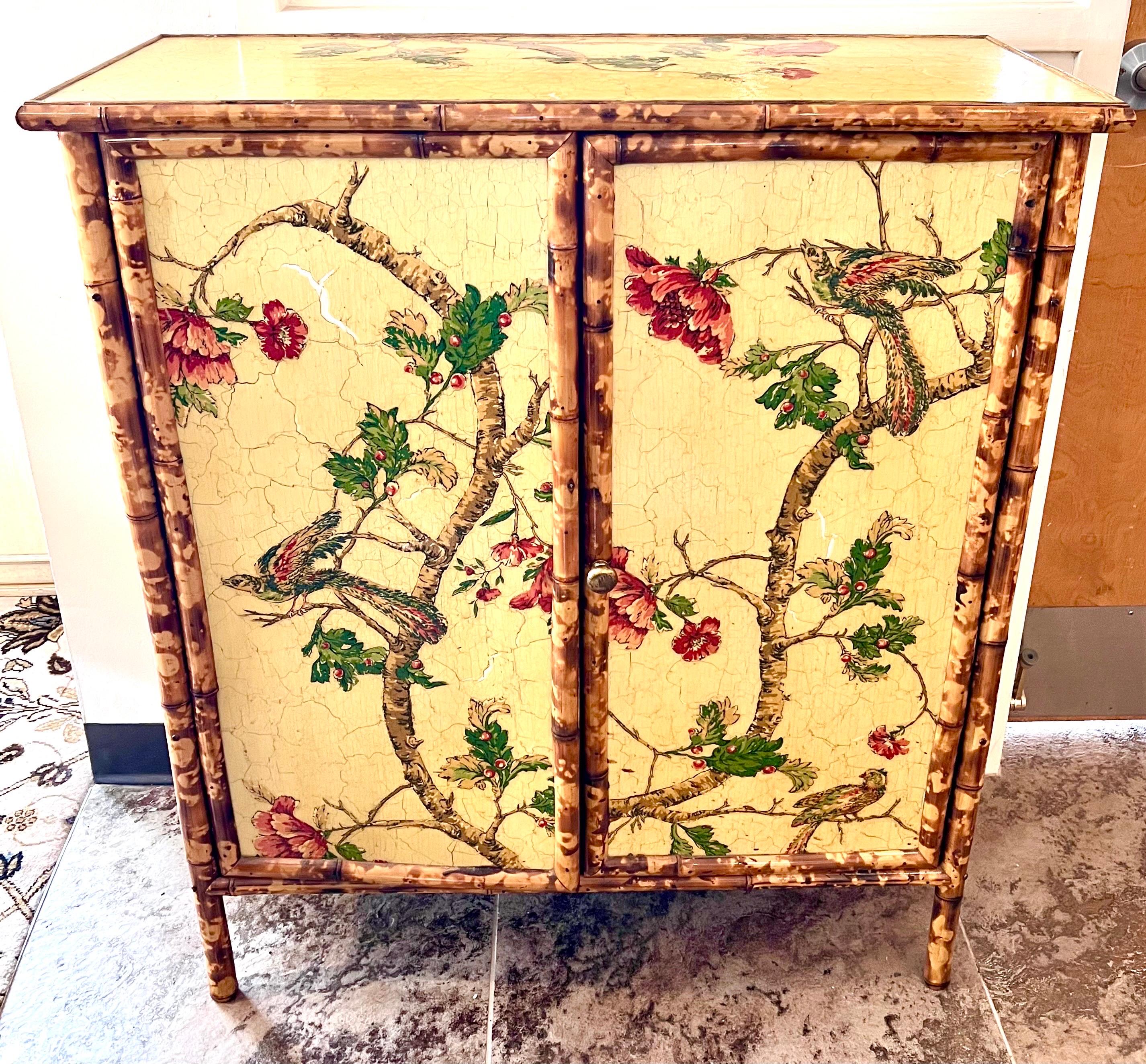 Unique one of a kind chinoiserie style pale yellow cabinet features a floral decoupage design all over with a crackled finish and is accented with faux bamboo trim with a tortoiseshell finish. Two doors open to shelves.  We are based on east coast