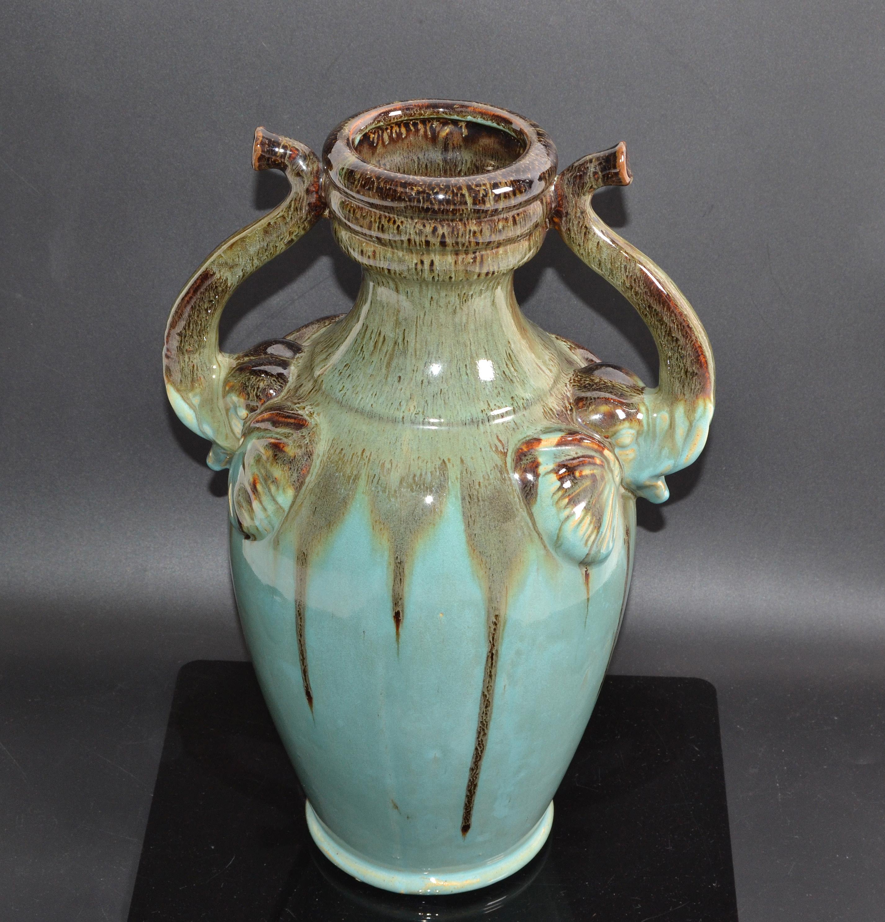 Marked glaze ceramic decorative urn, vase in terracotta and elephant handles.
Finished in a beautiful warm Turquoise and Brown Hue with smooth Textures.
Marked at the Base E and signed.