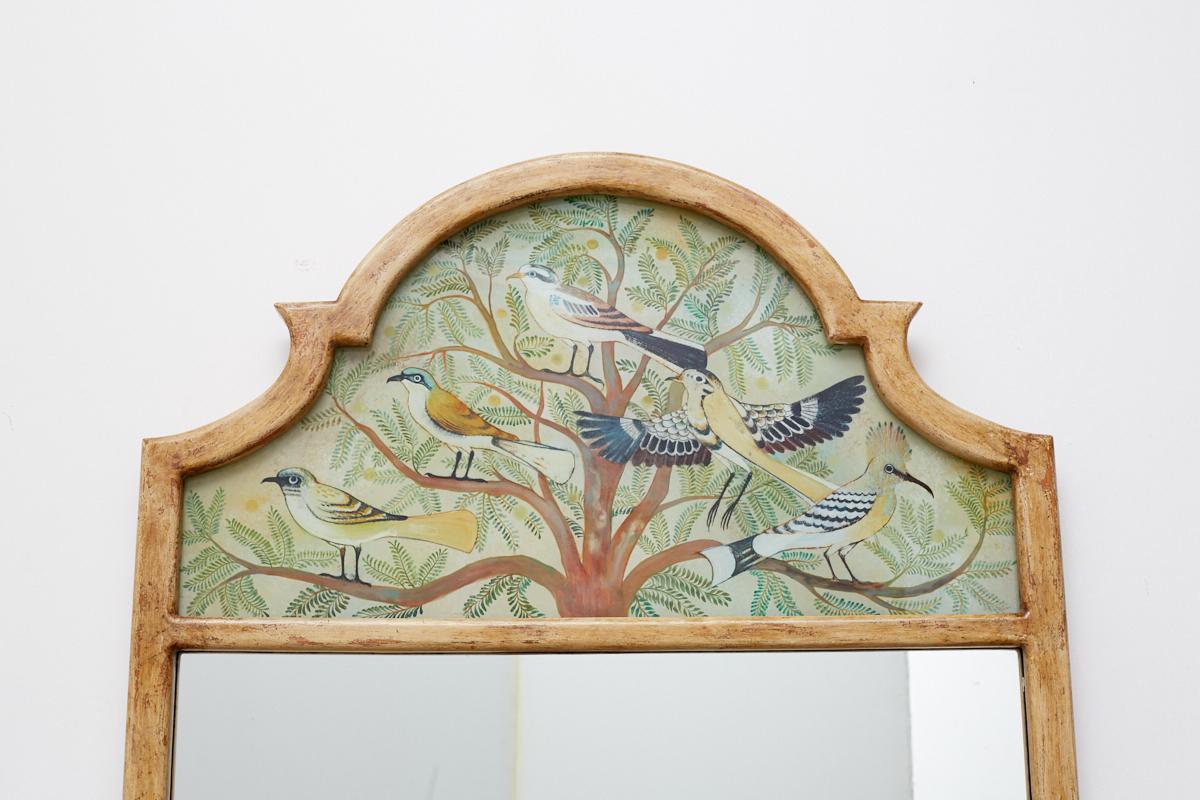 Beautiful reverse painted églomisé style Trumeau mirror featuring an ornithological painted window depicting birds in a tree. Made in the chinoiserie taste with a thick lacquered frame having a shield style form.