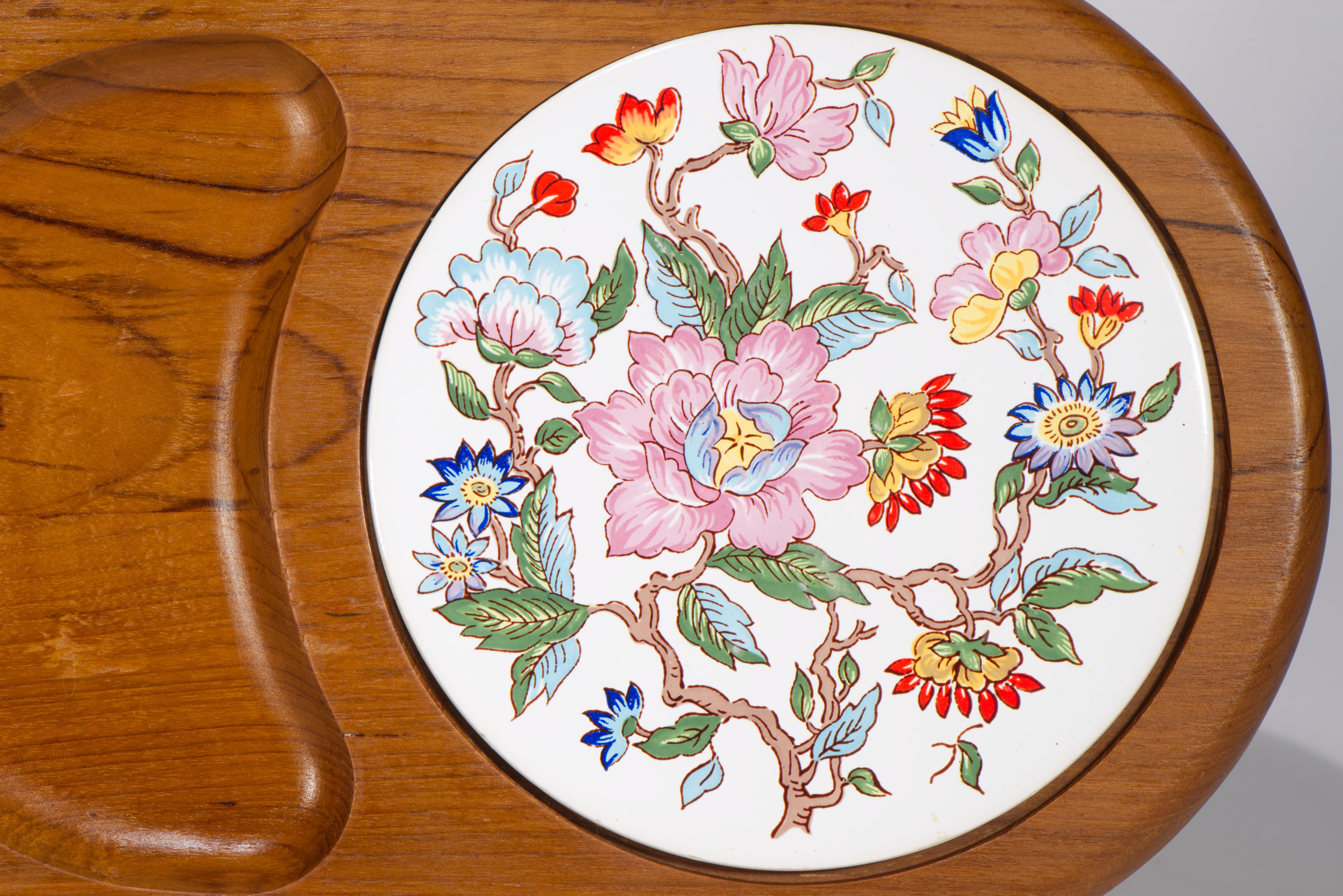  Cheerful vintage serving tray features a carved solid teak body with porcelain insert; the bright, colorful Chinoiserie style decor stands out against crisp white porcelain background, adding traditional element to a Mid Century Modern style shaped