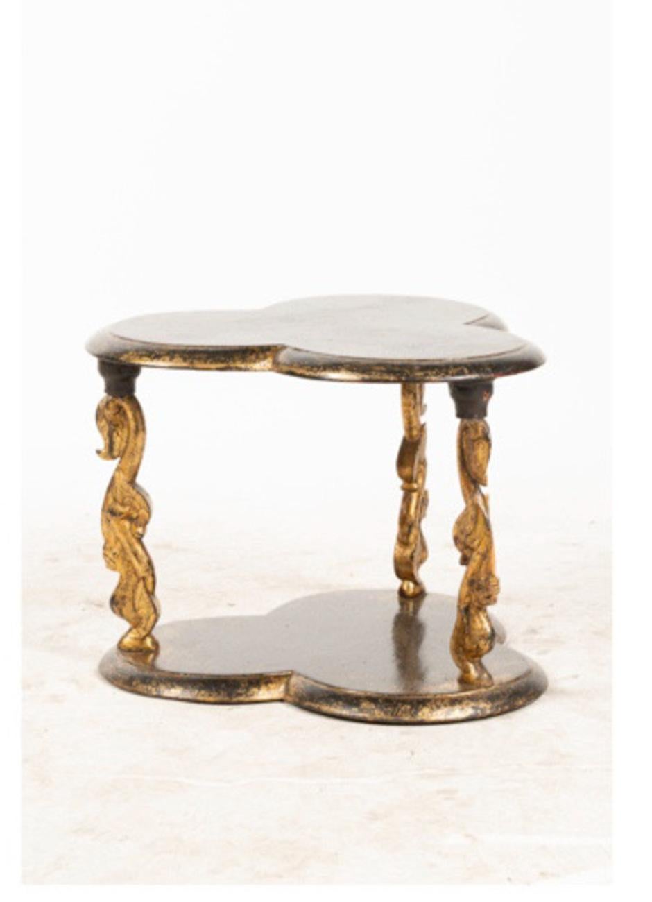 This is an uncommon form of small table that is in the style of Rose Tarlow or Mario Buatta. The table is ebonized with applied gold chinosierie decoration. The faux patina has been applied by a true artist. The table is in overall very good