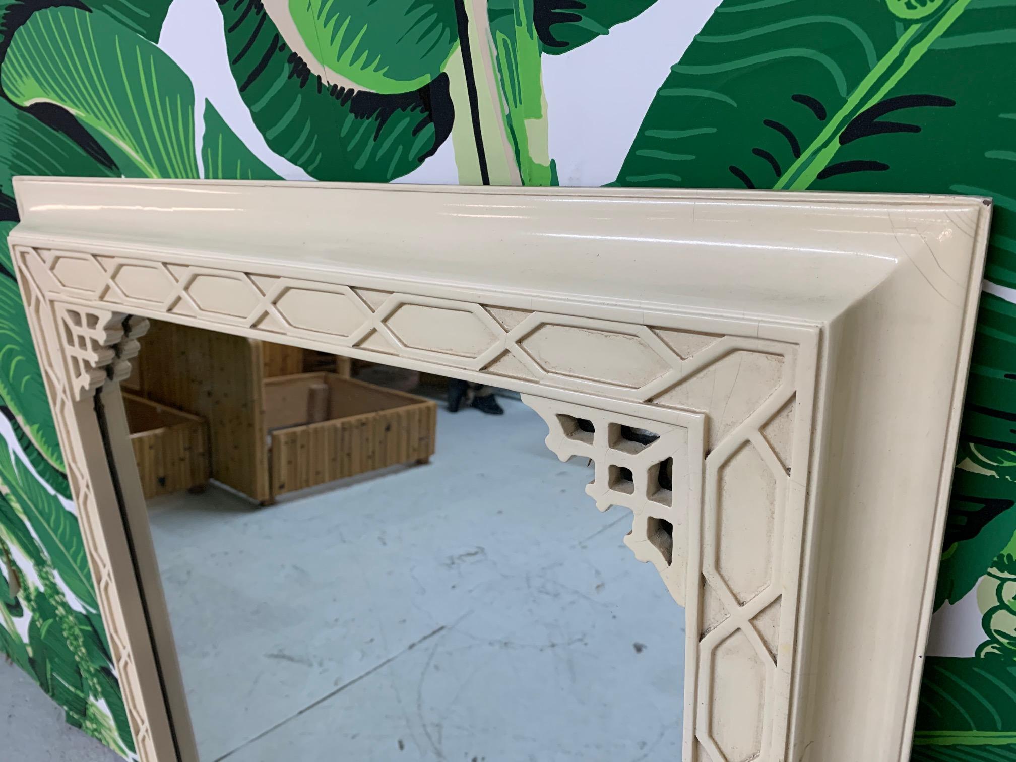 Vintage wall mirror by Gampel Stoll features fretwork detailing in chinoiserie style. Good condition with minor imperfections consistent with age.