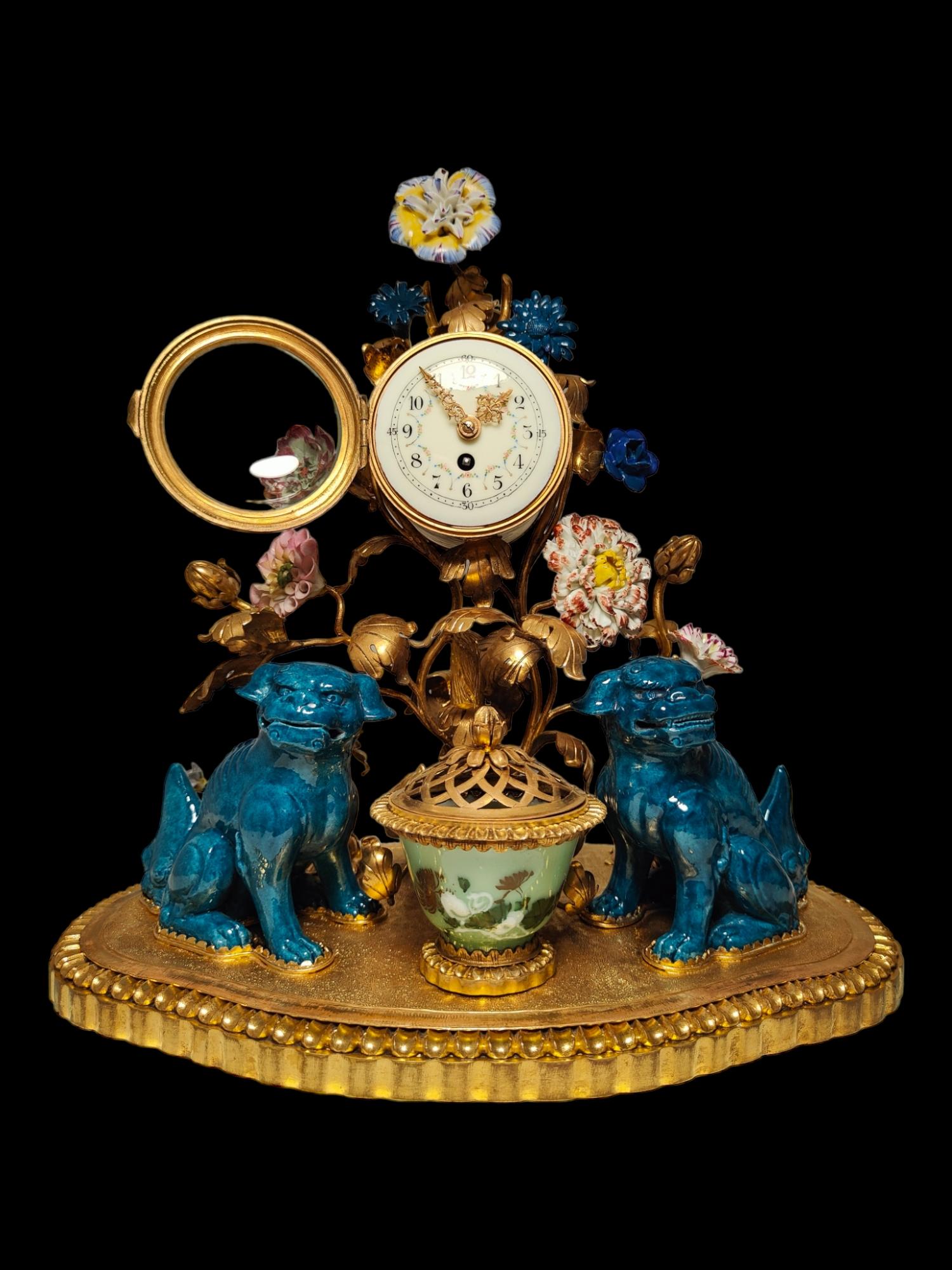 Chinosoiserie style gilt bronze and porcelain clock.
The misnamed ‘kylins’ of the time-honoured title of this clock are the pair of squatting lions of turquoise- and purple-glazed porcelain from the first half of the 19th century which flank the