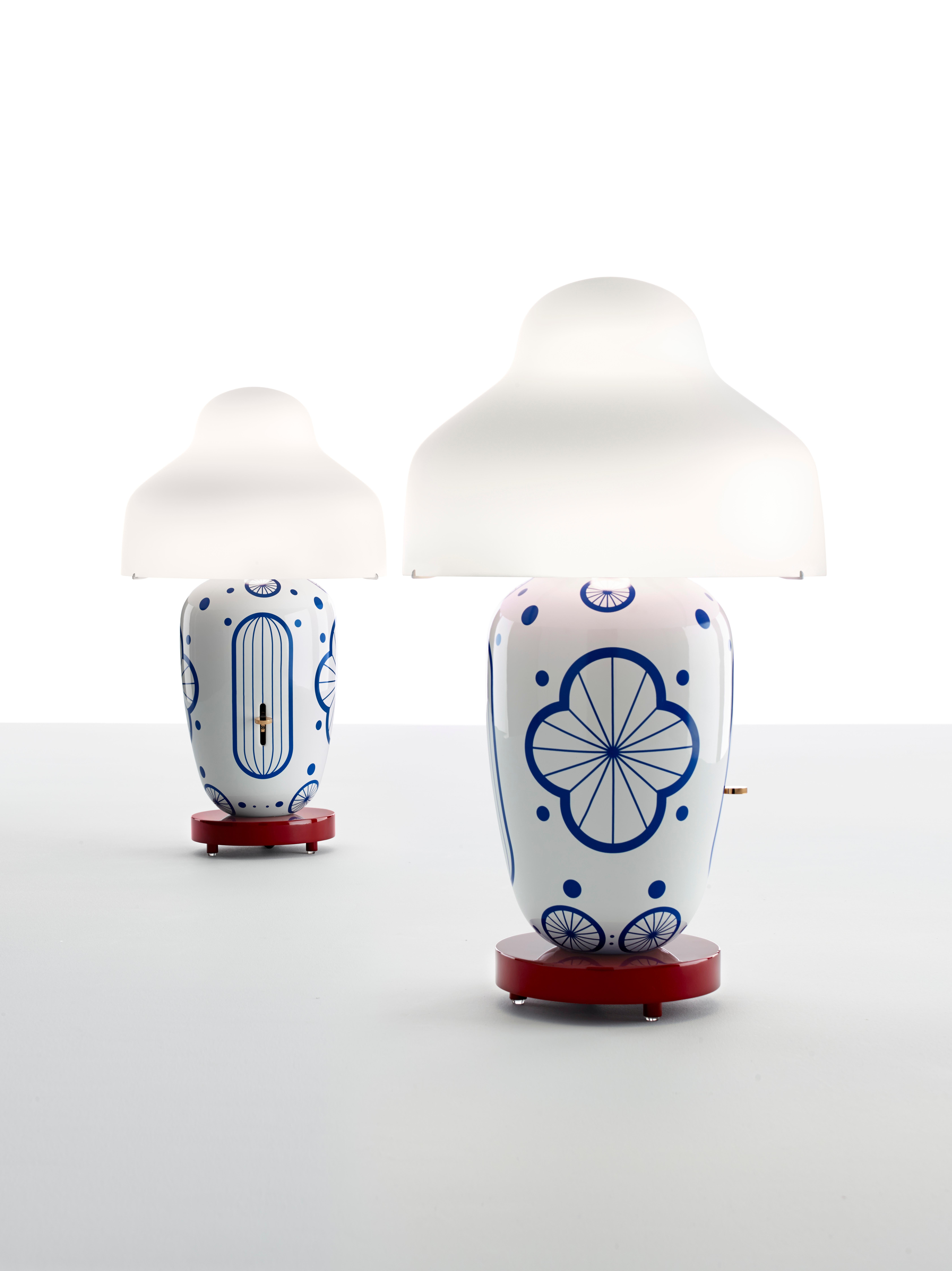 Chinoz

Table lamp. Body in black, red, pale green, Ming or Jùyuàn ceramic. Opal matt, glossy white or black diffuser. Base in black, burgundy, ocher or jùyuàn glossy lacquered wood. Sl
iding dimmer with polished brass handle, placed on the body.