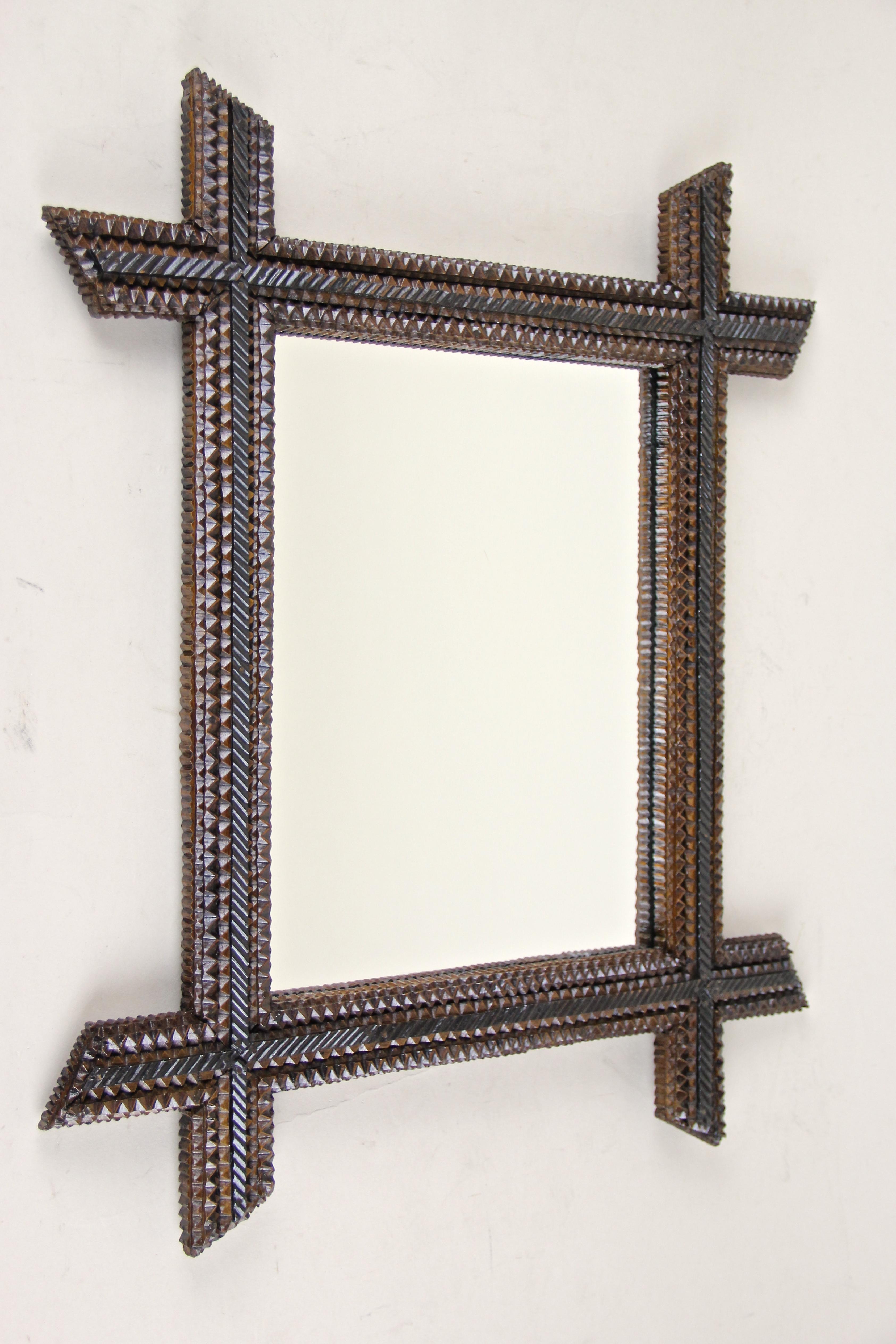 Fantastic chip carved Tramp Art wall mirror in our high-demand Tramp Art collection. This charming mid-sized rustic mirror comes from Austria around 1880 and convinces by its great variety of different chip carvings. Protruding, beveled corners and