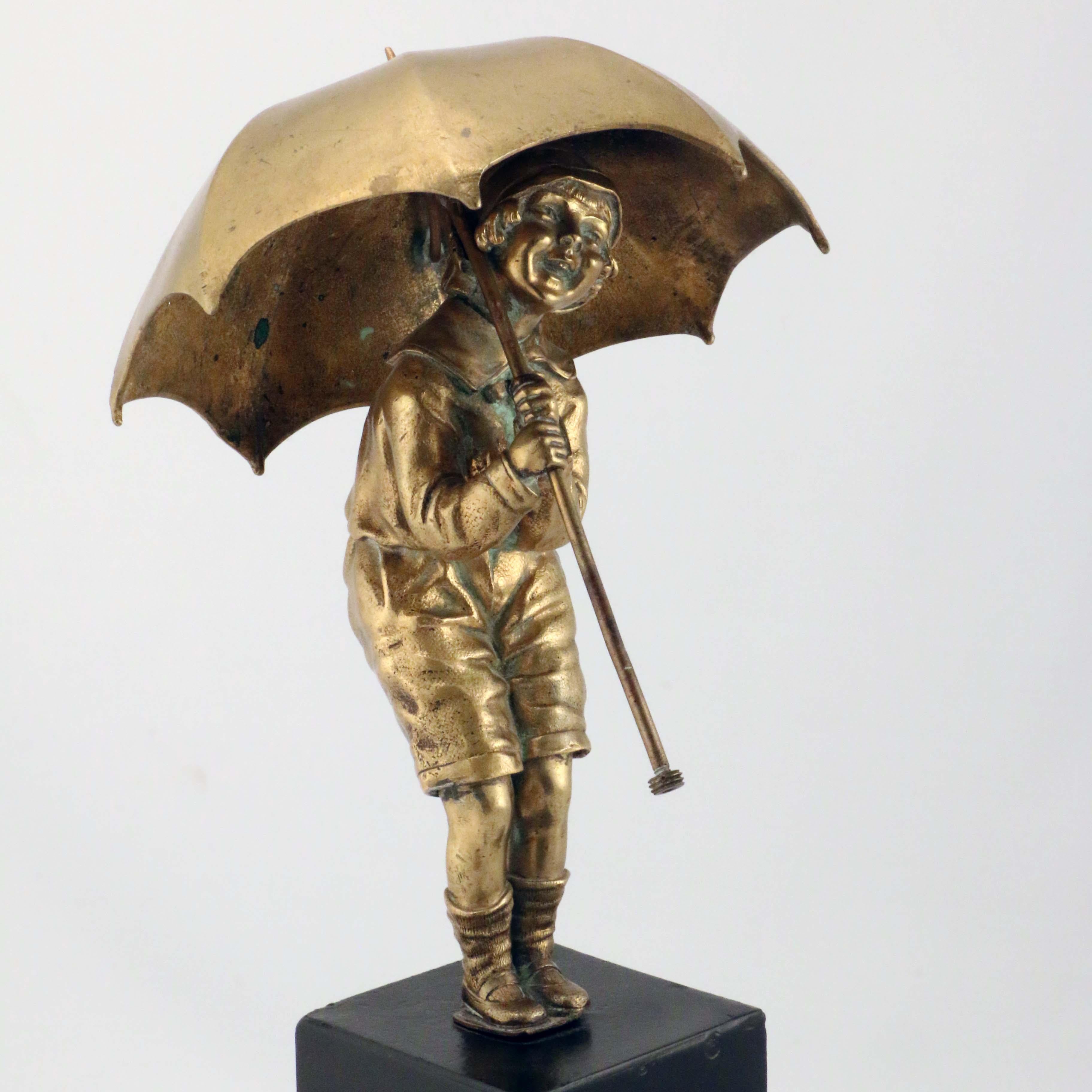 This charming treatment shows a girl of perhaps seven or eight sheltering from the rain under a large umbrella. Chiparus is celebrated for his exciting exotic dancers in bronze and ivory. Here he shows a tenderness and regard for a more quotidian