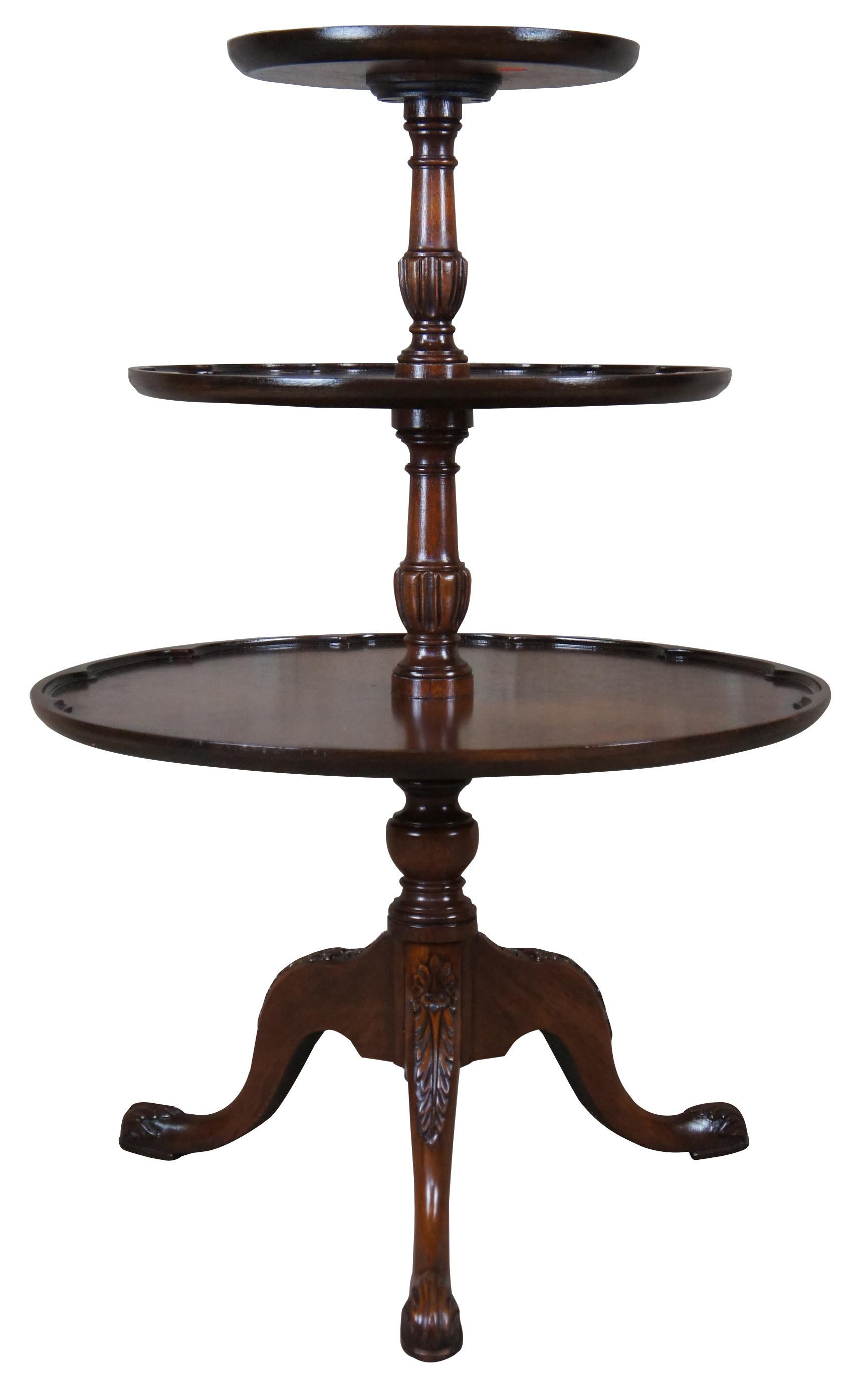 Vintage three tiered pie crust dumbwaiter or butlers table. Made of mahogany featuring chippendale styping with inset scalloped gallery on each tier and tripod base with acanthus accents.
    
