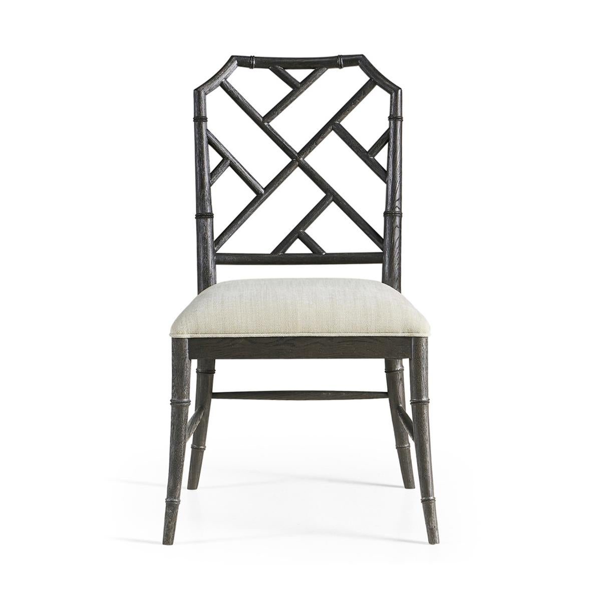 Chippendale bamboo dining chair, this timeless geometric design lattice back bamboo formed dining side chair in an ebonized finish with light distressing. Upholstered in earthy oatmeal performance fabric, the chairs will add comfort and intrigue to
