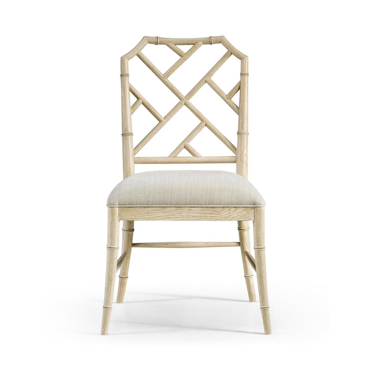 Chippendale Bamboo dining chair, this timeless geometric design lattice back bamboo formed dining side chair in a light oak finish with light distressing. Upholstered in earthy oatmeal performance fabric, the chairs will add comfort and intrigue to