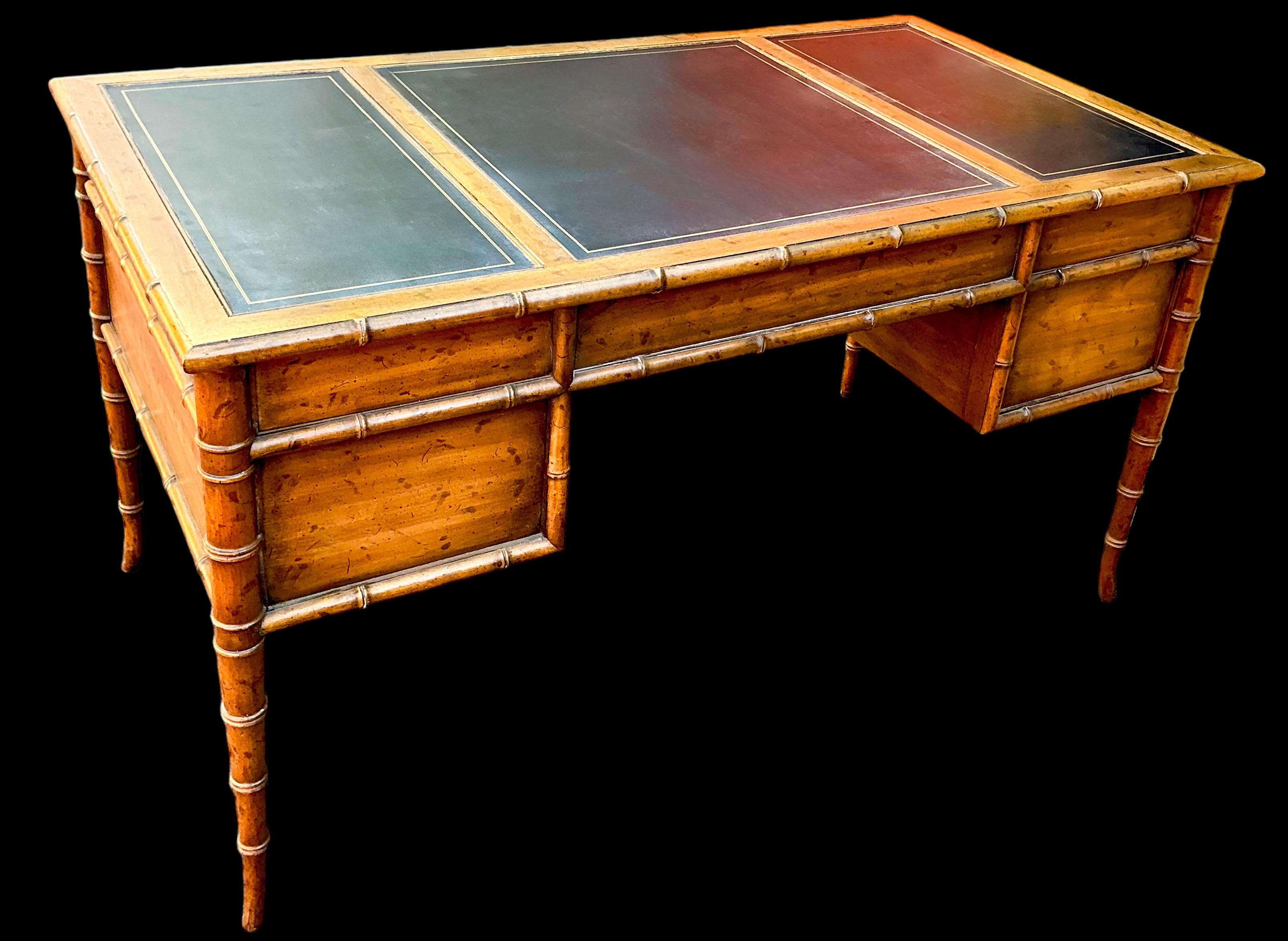 This has timeless appeal! It is a carved fruitwood faux bamboo desk with tooled leather top and brass campaign style hardware. The finish is intentionally distressed. It is unmarked and in very good condition.

Shipping can run 2 to 5 weeks. For