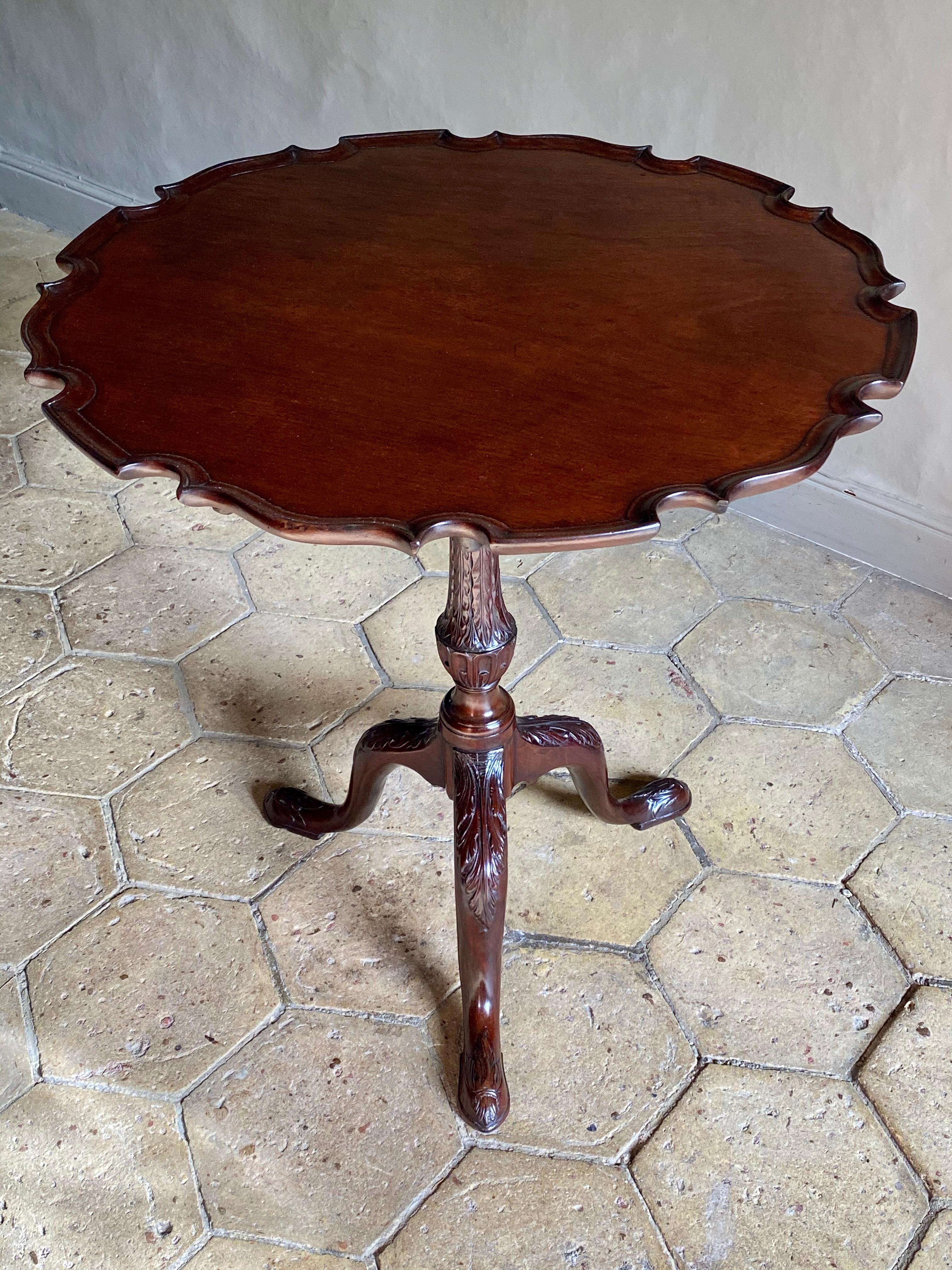 An English Chippendale period carved pie crust tripod table in mahogany of deep rich color.
George II, circa 1755.

This fine antique 18th-century table has a one-piece, well-carved top raised on a ‘bird cage’ action, allowing the top to swivel and