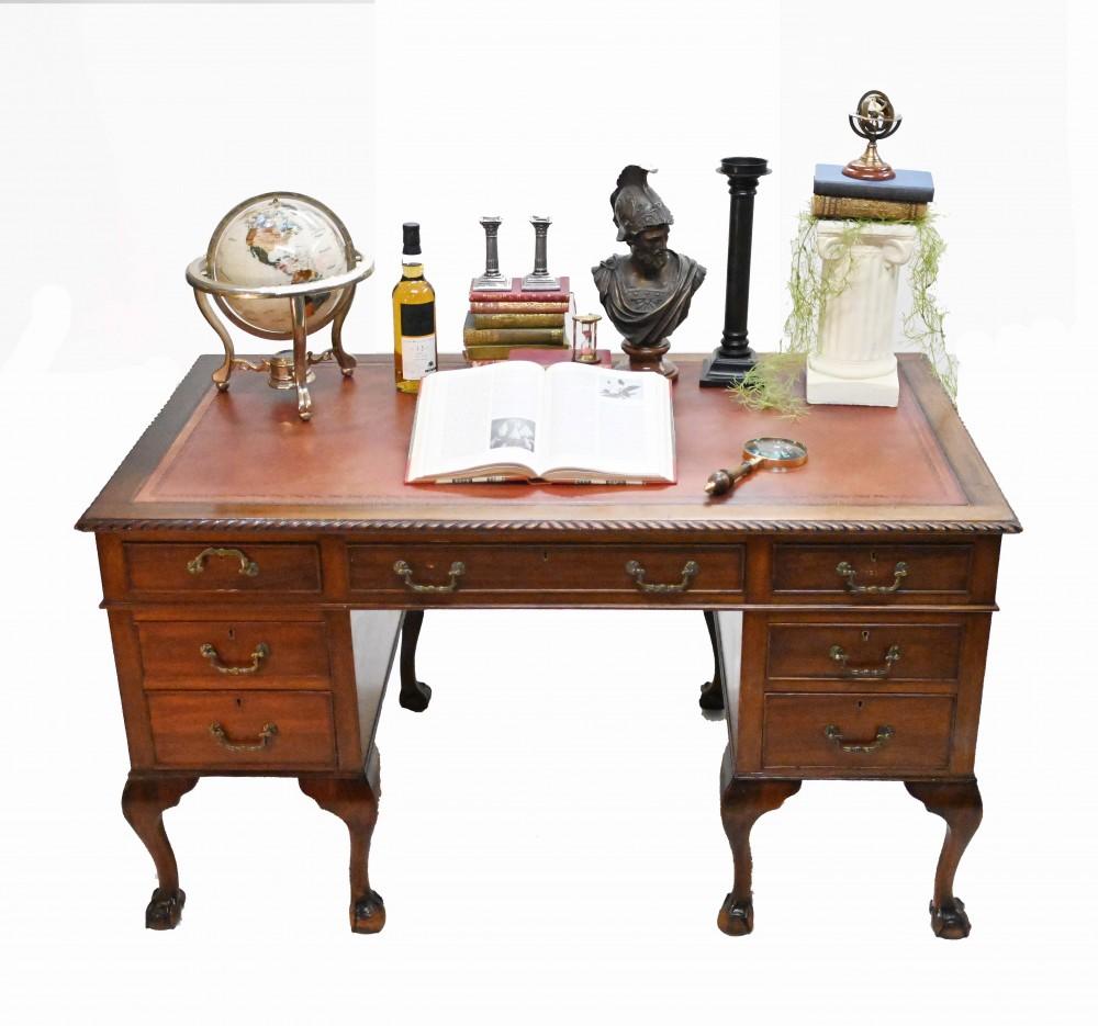 Raffinierter Mahagoni-Schreibtisch im Chippendale-Stil
Mit Schwanenhalsgriff-Zugfronten, die auf Blutkugel- und Krallenbeinen enden
Die Oberseite ist mit einem Einsatz aus genarbtem Leder versehen
Klassische Chippendale-Kuchenkruste an der Oberseite