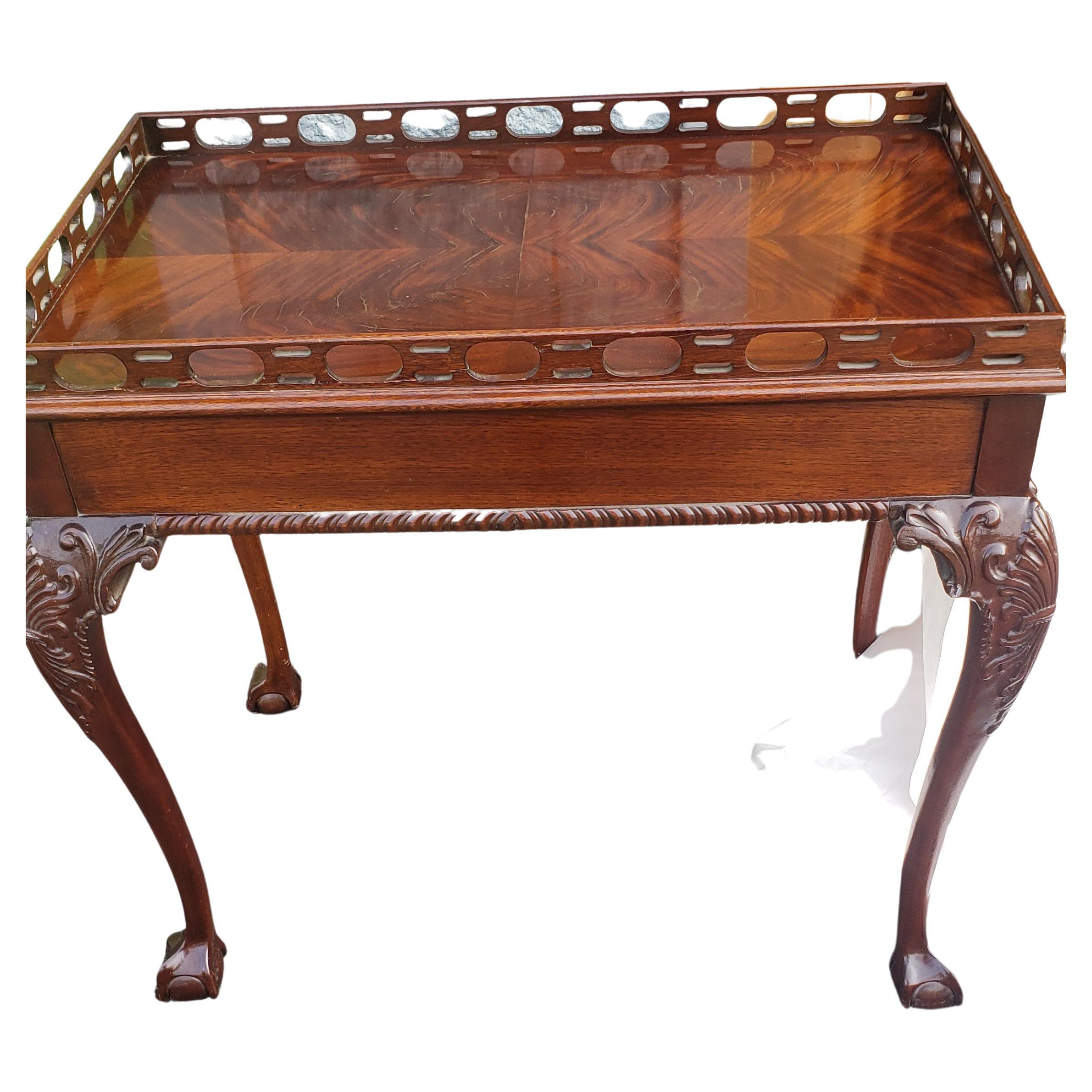 Chippendale Flame Mahogany tea table with Pierced Gallery, carved cabriole legs terminating with ball and claw feet. Attributed to Councill Craftmen Furniture. Good vintage condition and measures 31