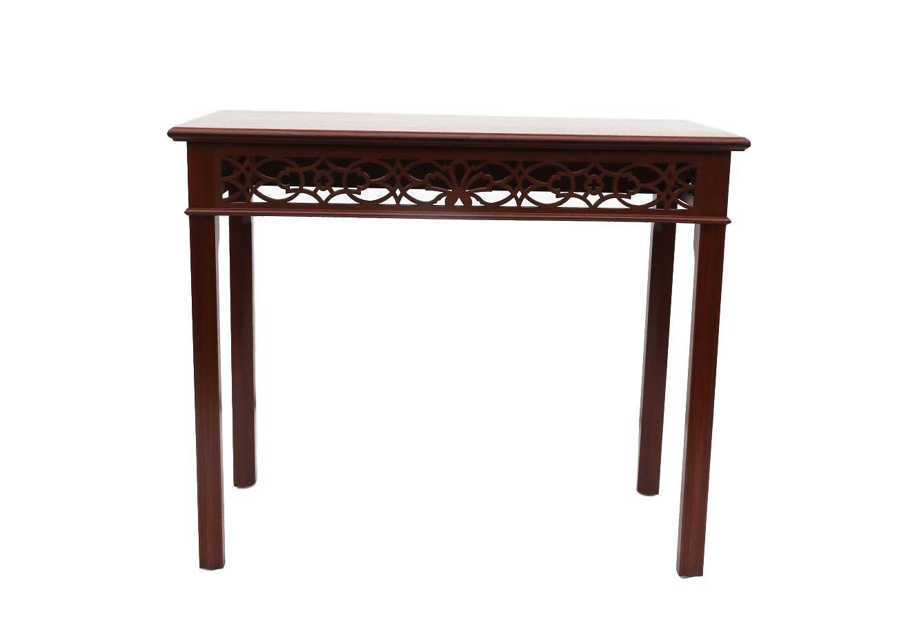 This very attractive walnut console table finely crafted and carved with beautiful open fretwork details on the front and both sides. No fretwork details at the back side. Featuring banded rectangle top with canted corners, moulded square legs, and