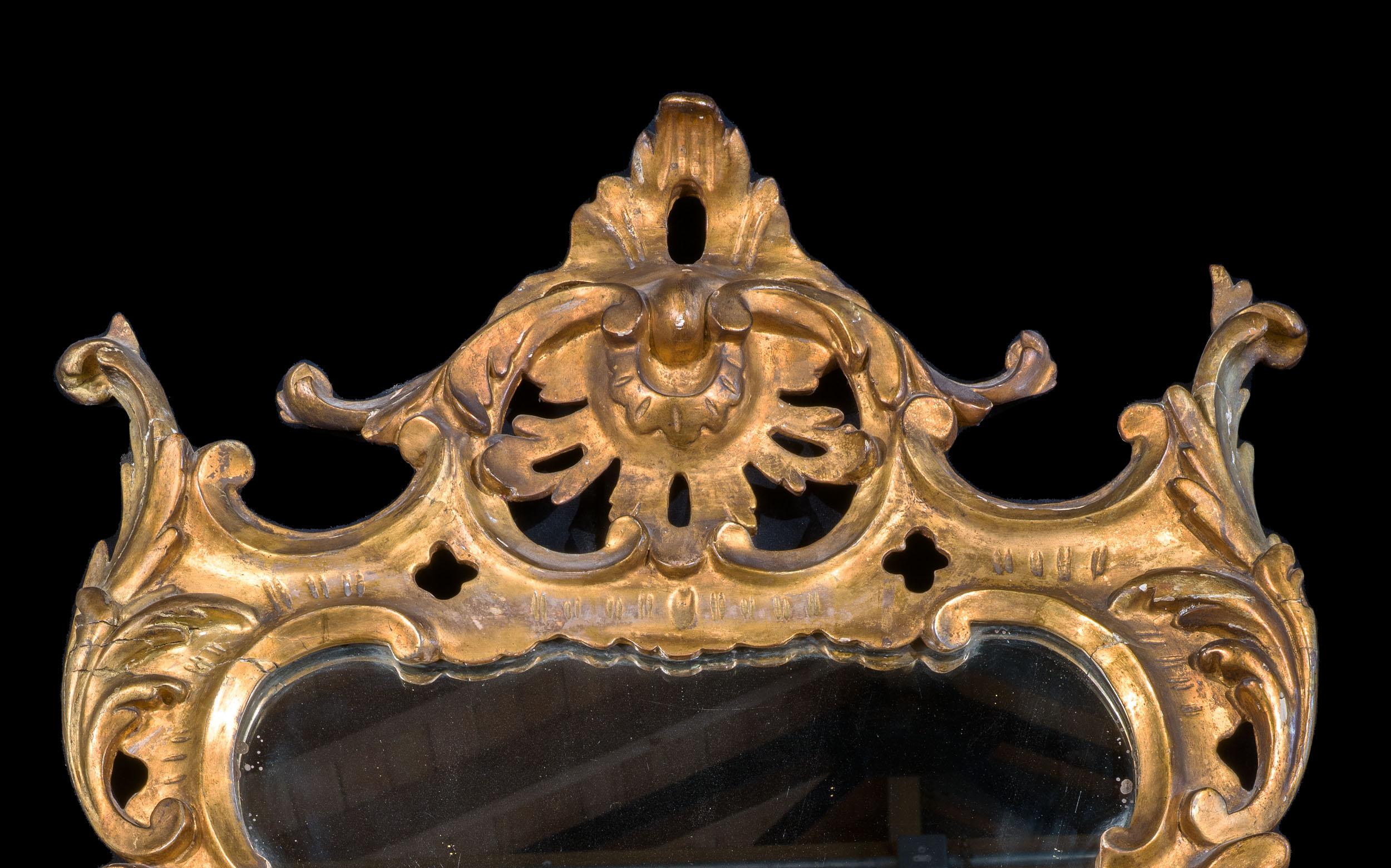 A fine George III Irish giltwood mirror. The elegant frame is carved with c scrolls and acanthus leaves, with floral garlands to the sides. The frame is surmounted by rocaille motif very much of the English Rococo style.

Irish, c.1760.