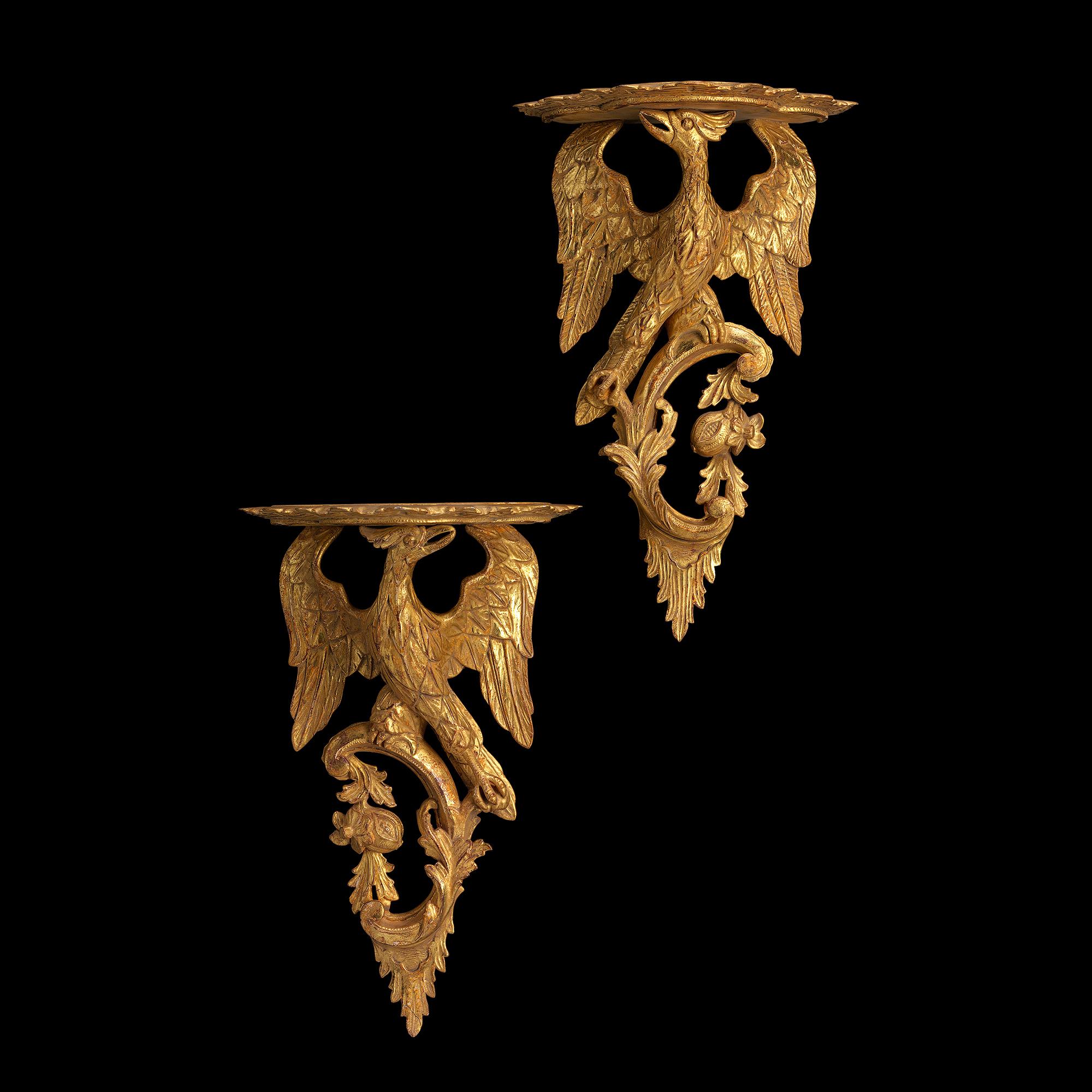 These carved glided wood brackets are in the style of the mid 18th century. The mythological Ho Ho bird supports a shaped and moulded shelf on its head and grasps a C scroll in its claws. The scroll is decorated with acanthus leaves, flowers and