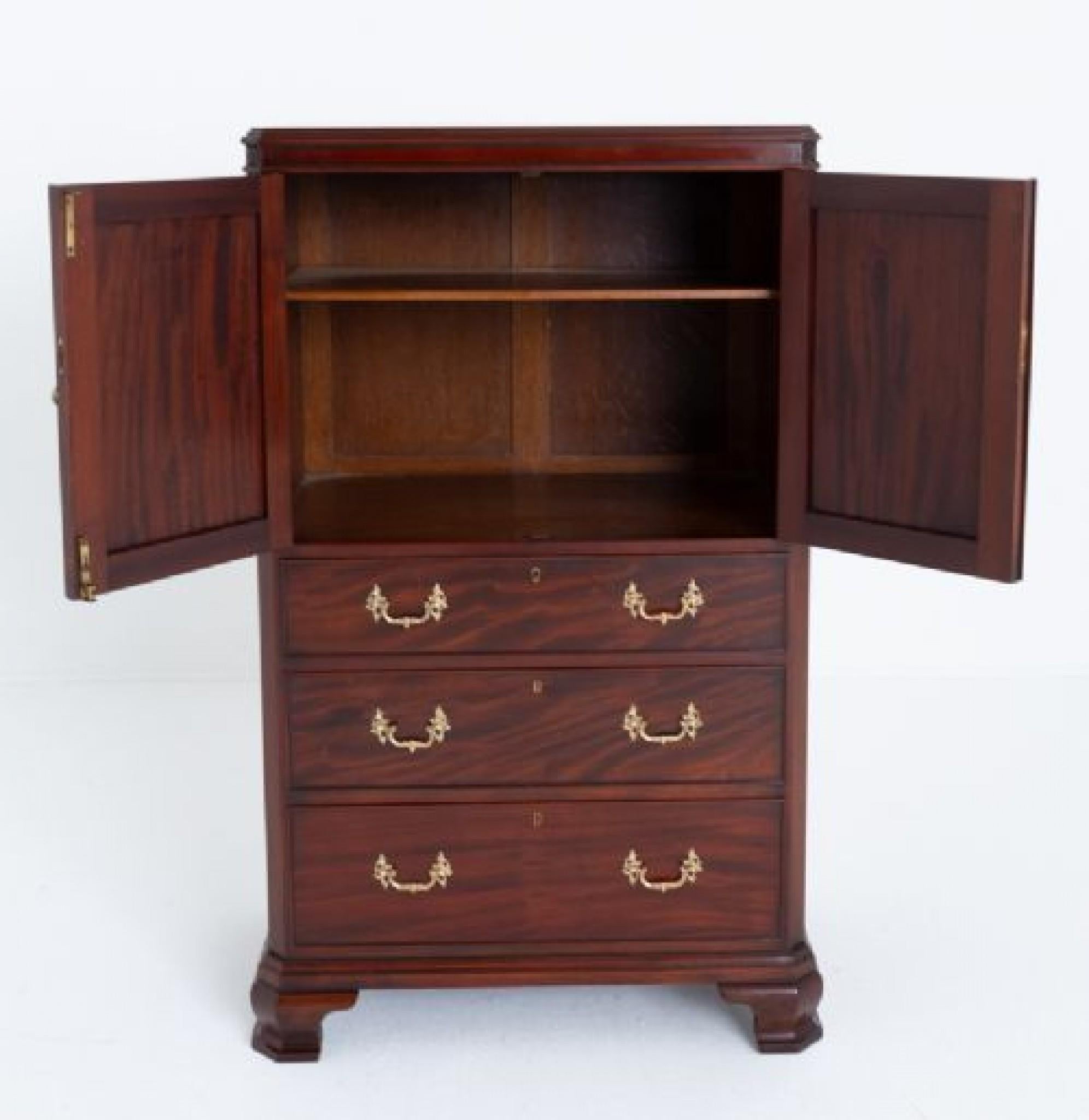 This high quality linen cabinet was made by lambs of manchester.
Standing upon ogee bracket feet.
The bottom of the cabinet having 3 oak lined graduated drawers which retain their decorative cast brass swan neck handles.
The upper section having 2