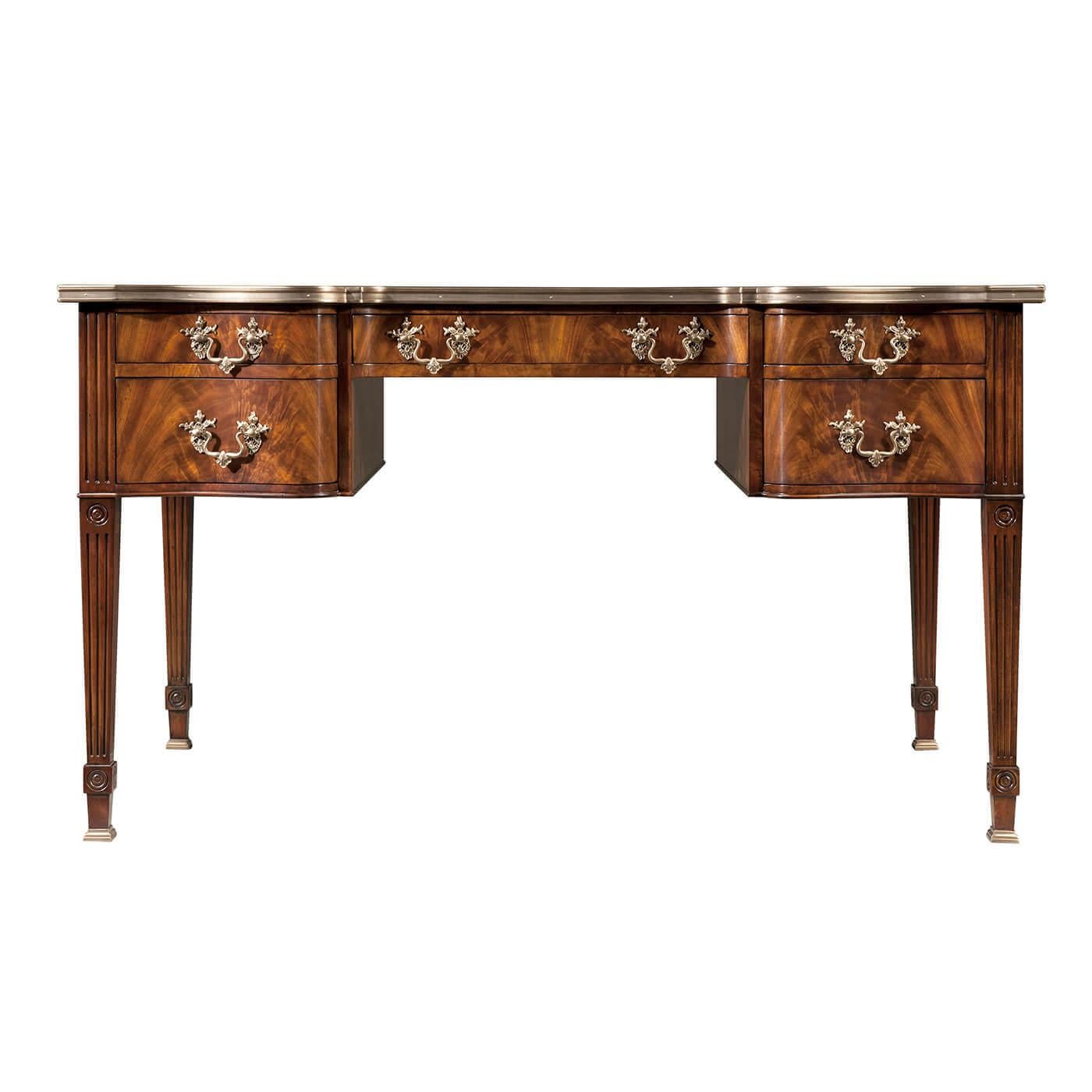A Chippendale style mahogany and flame veneered bureau plat desk, the serpentine brass bound top above five drawers creating a kneehole, on square fluted legs.
Dimensions: 55