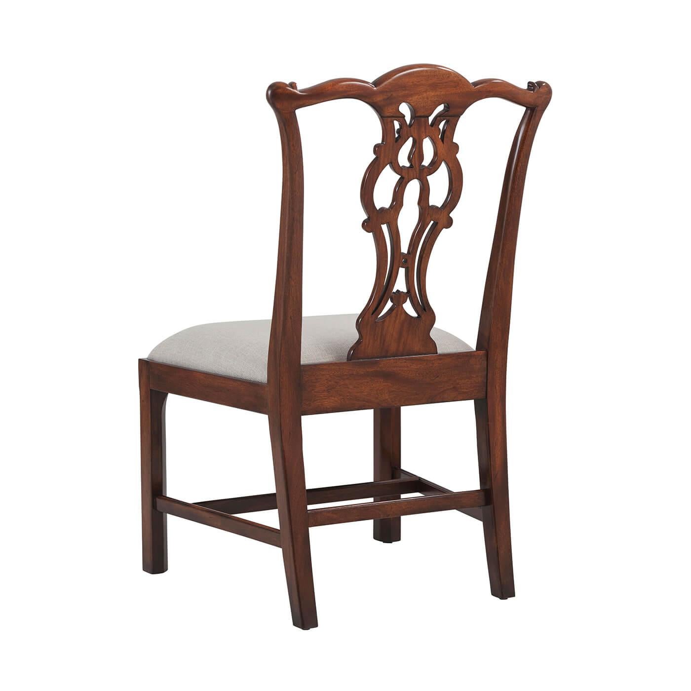 Sedia da pranzo in mogano intagliata a mano alla maniera di Thomas Chippendale, con la parte superiore a serpentina sopra una stecca a vaso traforato, il sedile imbottito a ribalta su gambe quadrate smussate unite da barelle. Ispirato a un originale