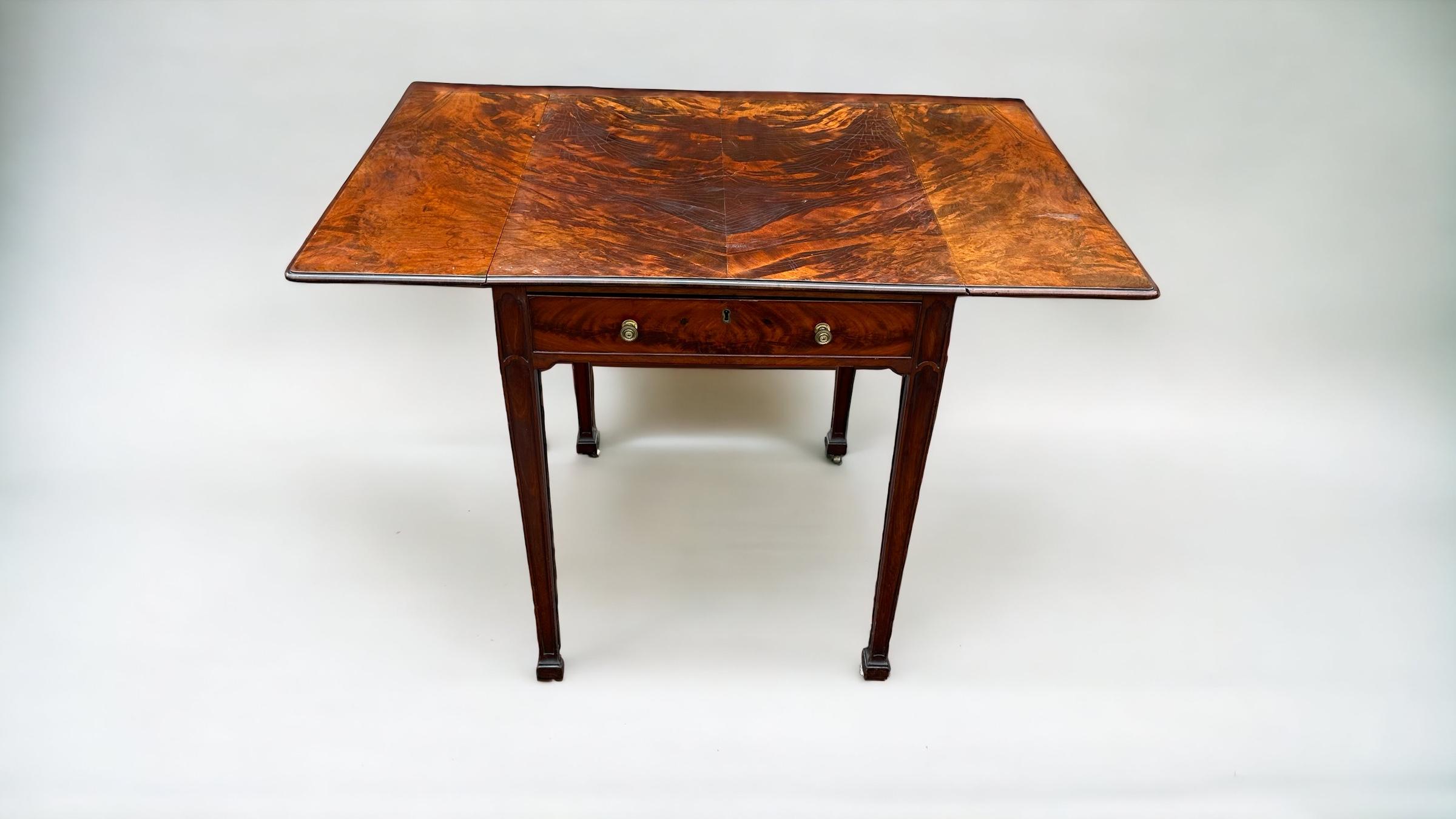 A fine mid 18th Century Chippendale period mahogany Pembroke table.
The top with exquisite & highly figured veneers with rounded corners & thumb moulded edge.
The base with frieze drawer and dummy to opposing side with brass axe head handles typical
