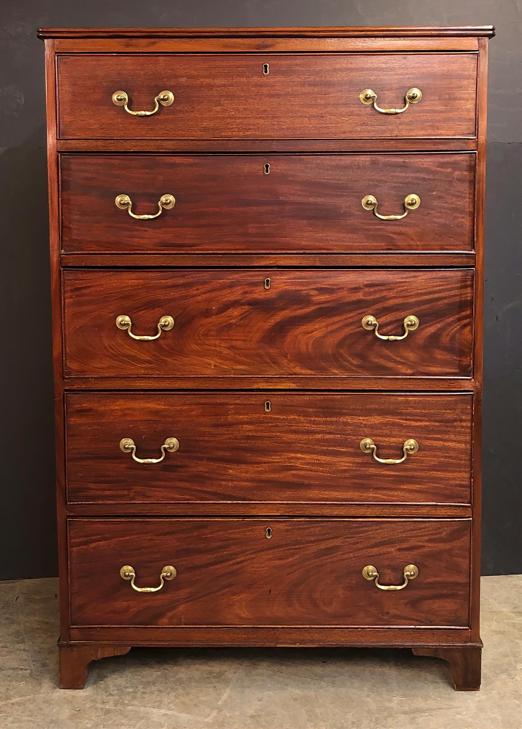 Chippendale mahogany five-drawer tall chest of drawers with reeded edge tp, graduated drawers, brass handles, and bracket feet.