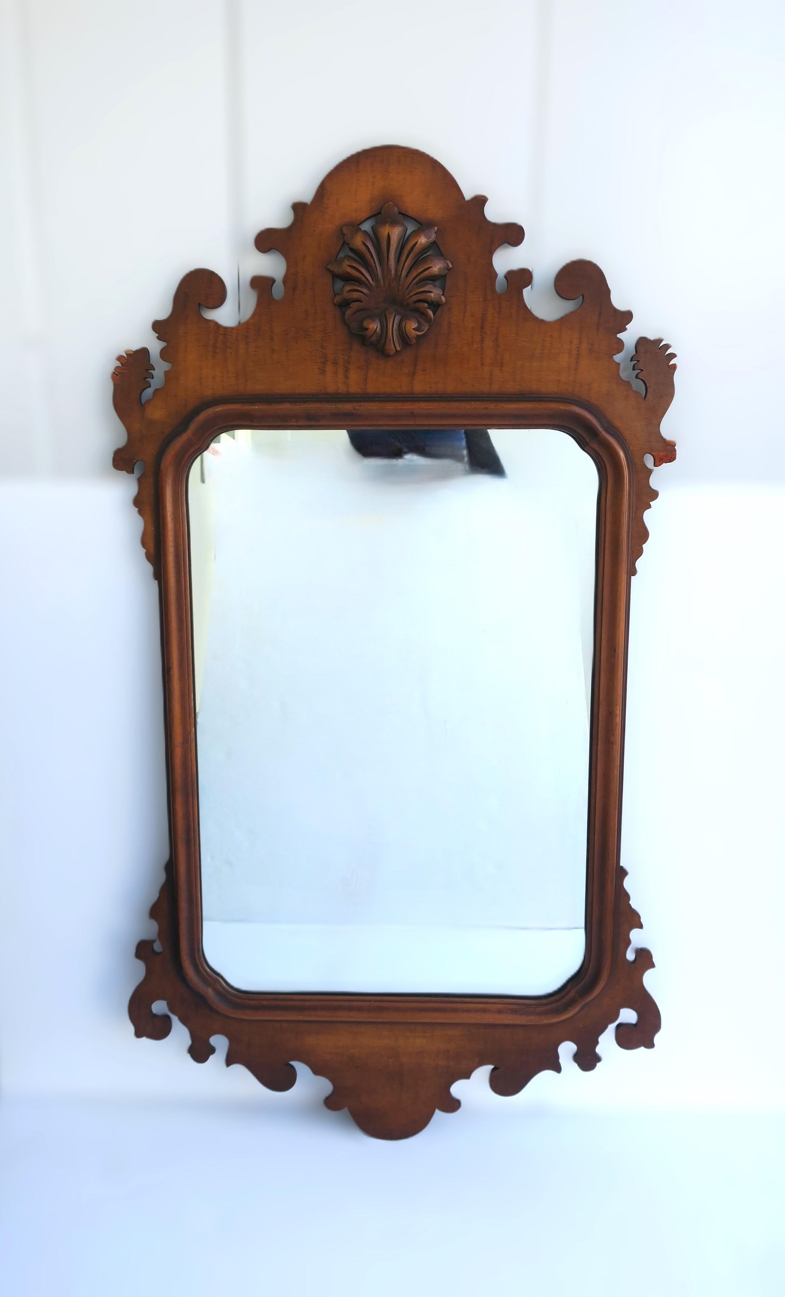 **Pair (2) available, each sold separately, as per listing. 

A beautiful English maple wood wall mirror, in the Rococo Chippendale style, circa 19th century, England. Mirror has a central carved crest in a leaf plume motif and craved top/sides and