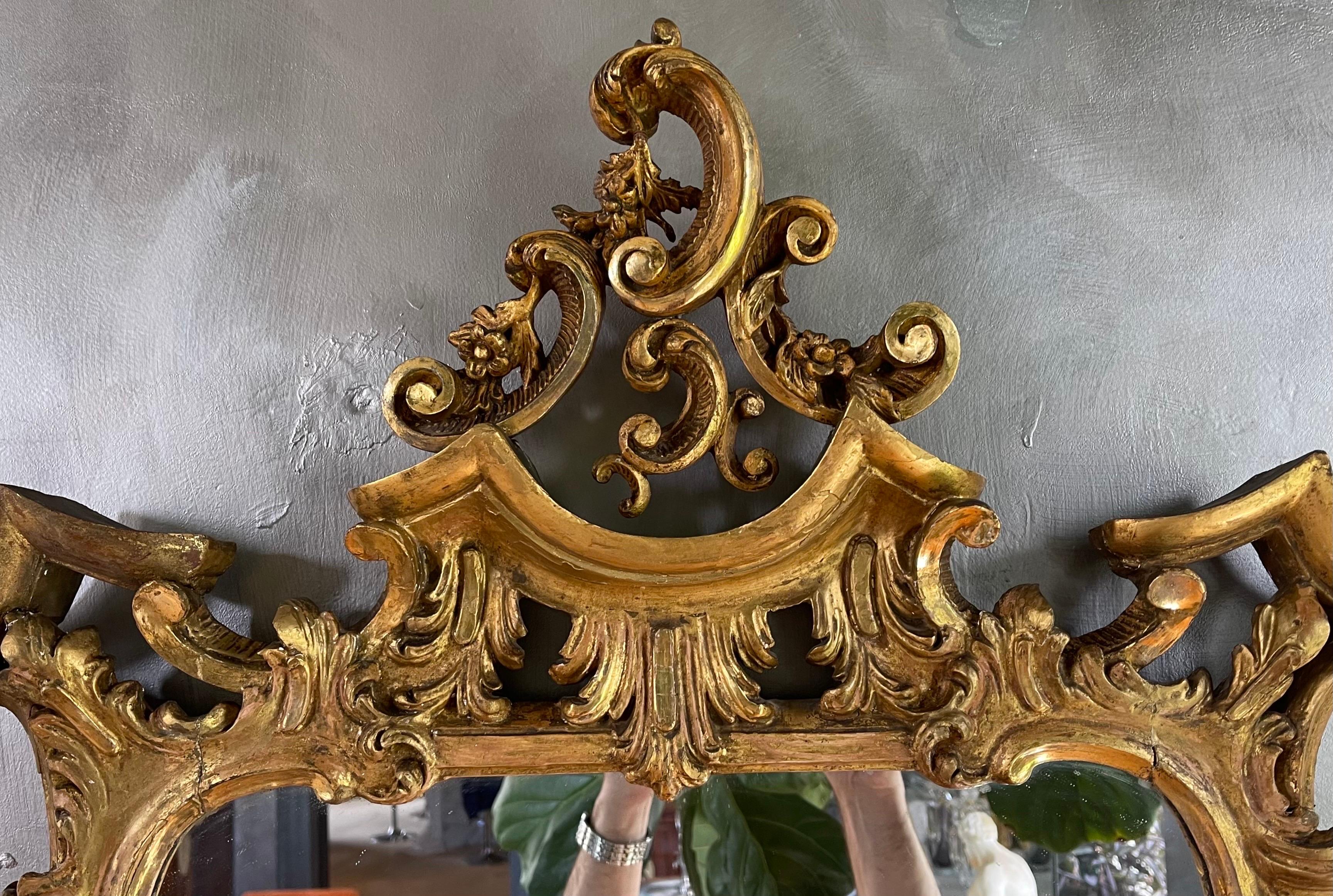 A very fine 18th century Chinese Chippendale looking glass. The foliate design incorporates three dimensional roses wrapping around columns and Rococo C-Curves finished in pagoda tops. It retains original 24k Guilding and desirable light terracotta
