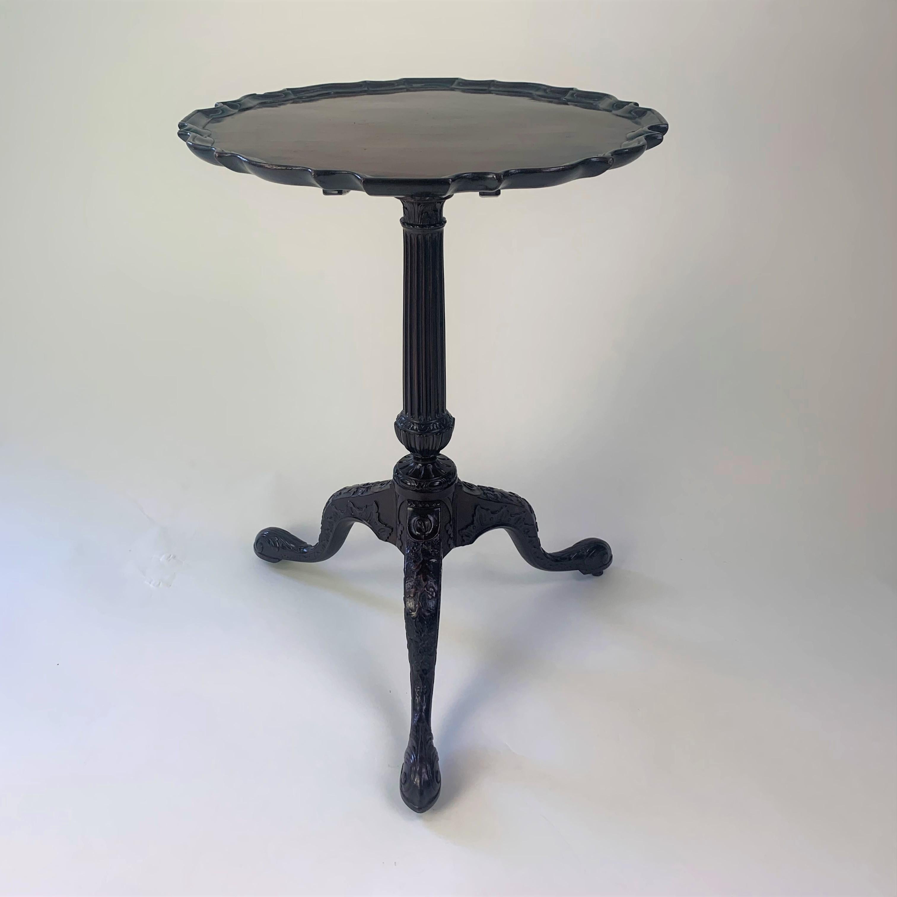 An outstanding mid 18th century figured mahogany tripod table. The one-piece top with finely carved pie-crust edge supported on a profusely carved 'blind-fret' base with fluted column carved to both the capital and base, raised on cabriole legs