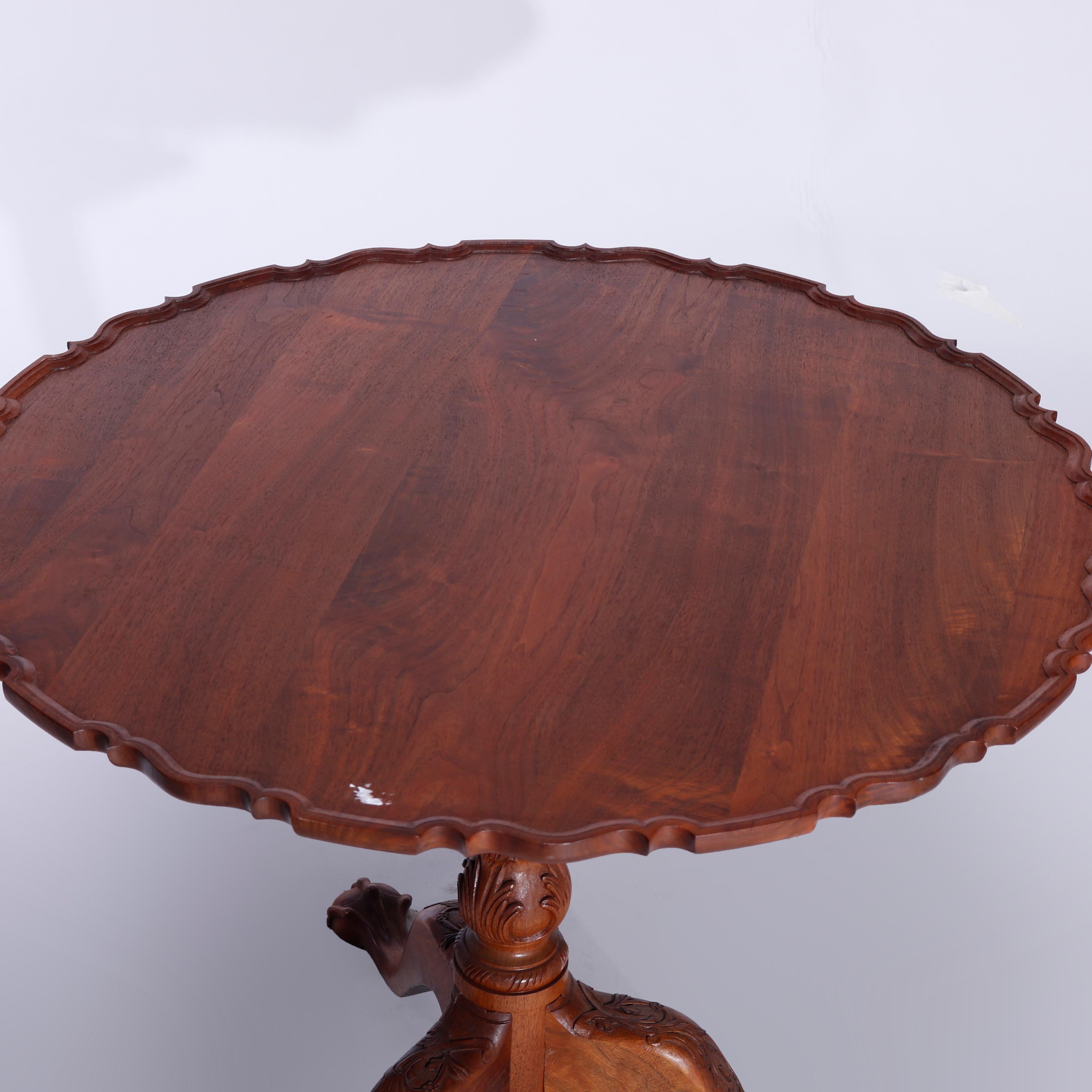 Ein kippbarer Tisch im Philadelphia-Chippendale-Stil bietet eine geformte Platte mit erhöhter Lippe über einer geschnitzten Säule mit geschnitztem Akanthus und steht auf Kabriole-Beinen, die in geschnitzten Krallenfüßen enden, 20 

Maße - 28,25''H x