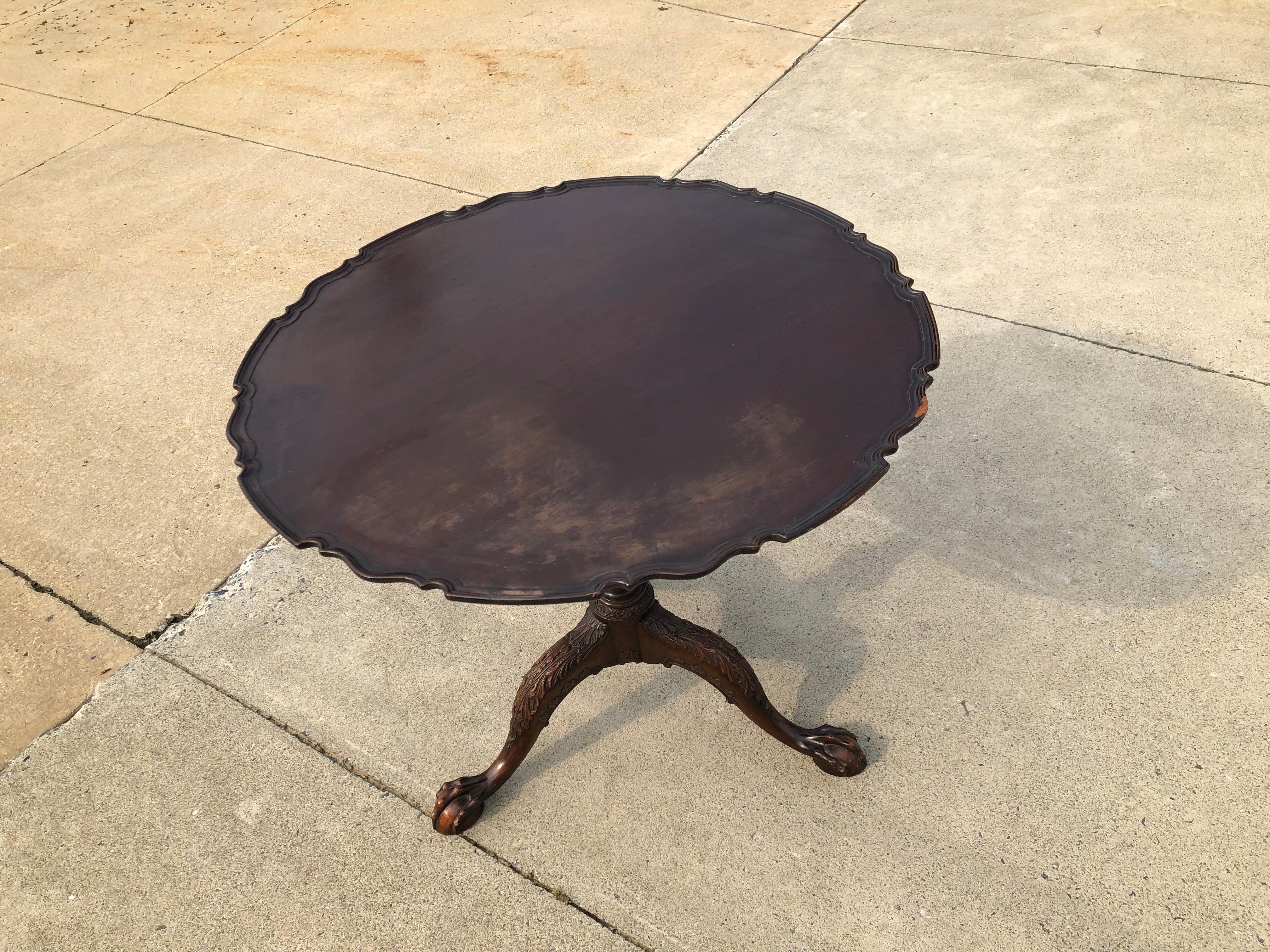 Chippendale carved and figured mahogany pie crust tilt-top tea table. The carving is possibly of Philadelphia and it retains its dark rich historic surface.
 