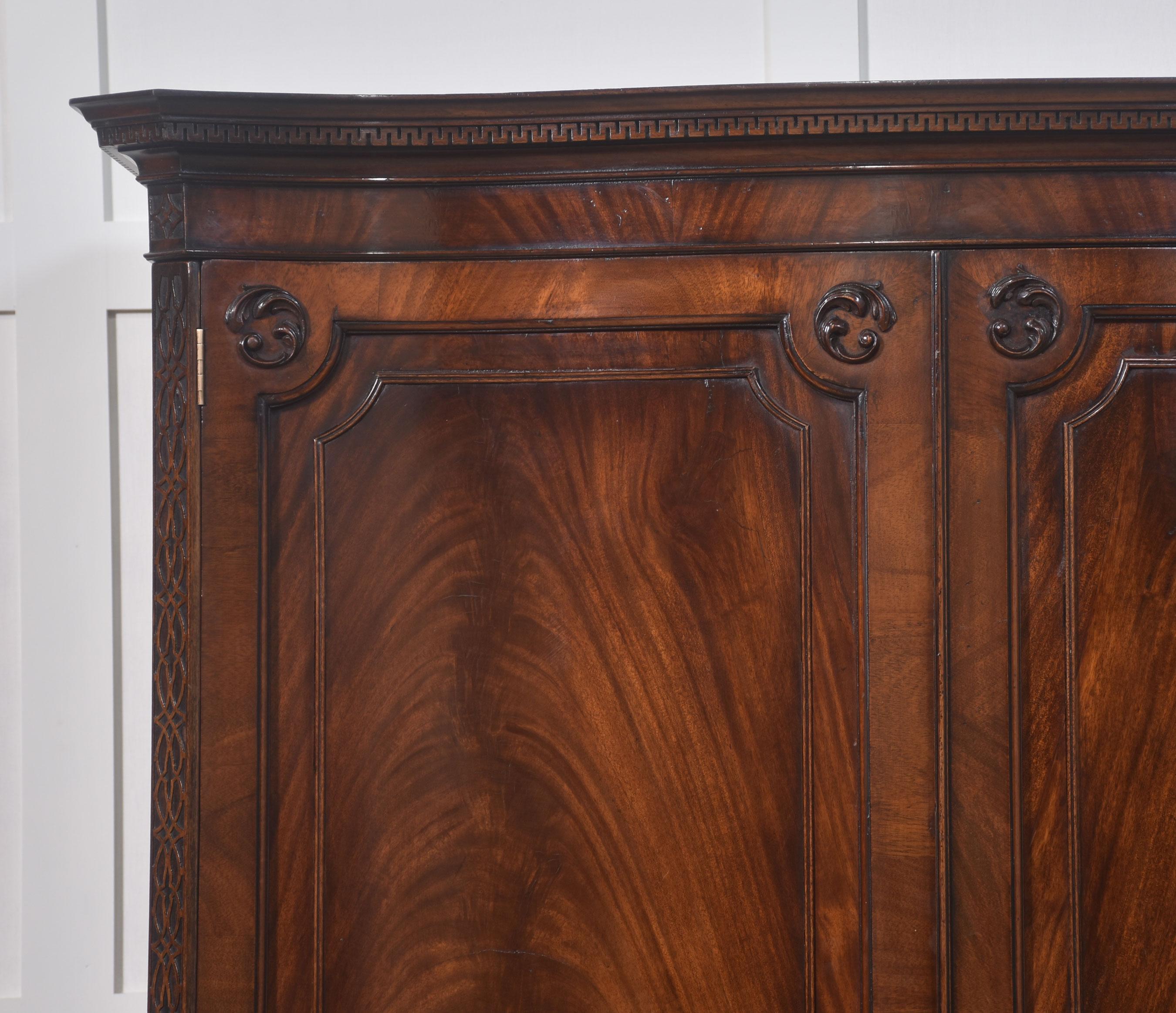 Armadio in mogano in stile Chippendale di forma serpeggiante con cornice sagomata e intagliata sopra due grandi ante in mogano a fiamma che si aprono per rivelare un'ampia zona d'appendimento. Sopra un grande e profondo cassetto singolo con maniglie