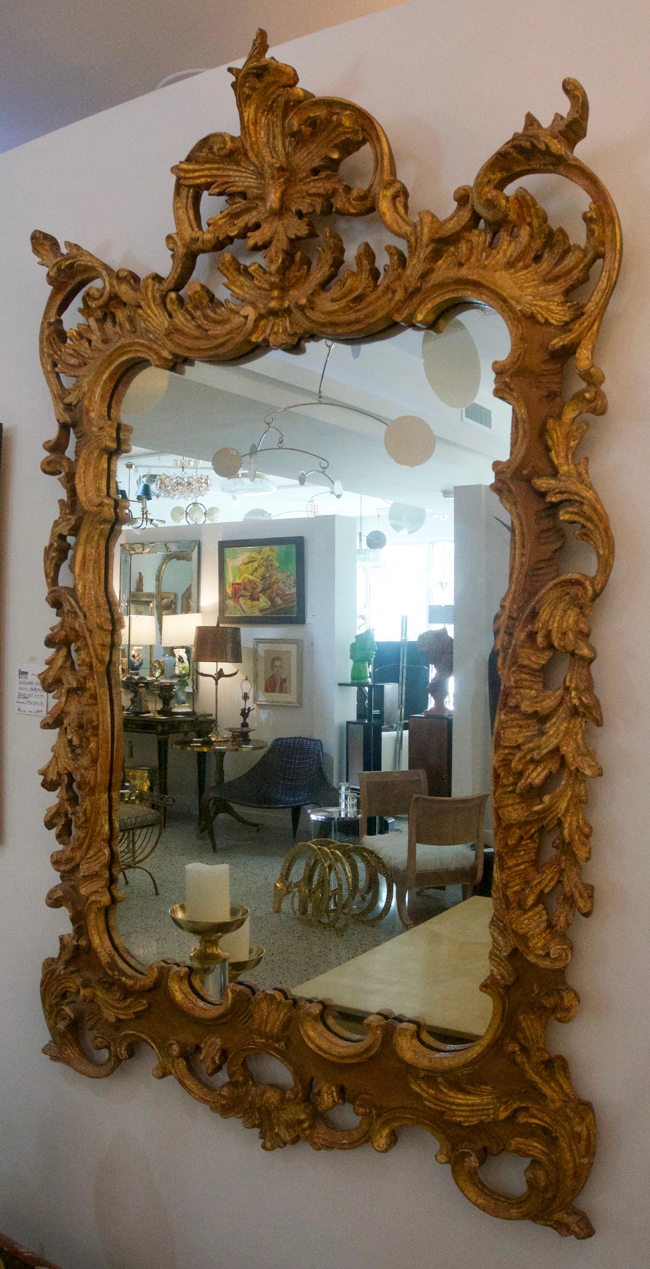 This beautiful hand carved wooden Chippendale Rococo style wall mirror is by the American firm of La Barge and was imported from Italy in the 1970s. The piece has a very warm and subtle antiqued finish.